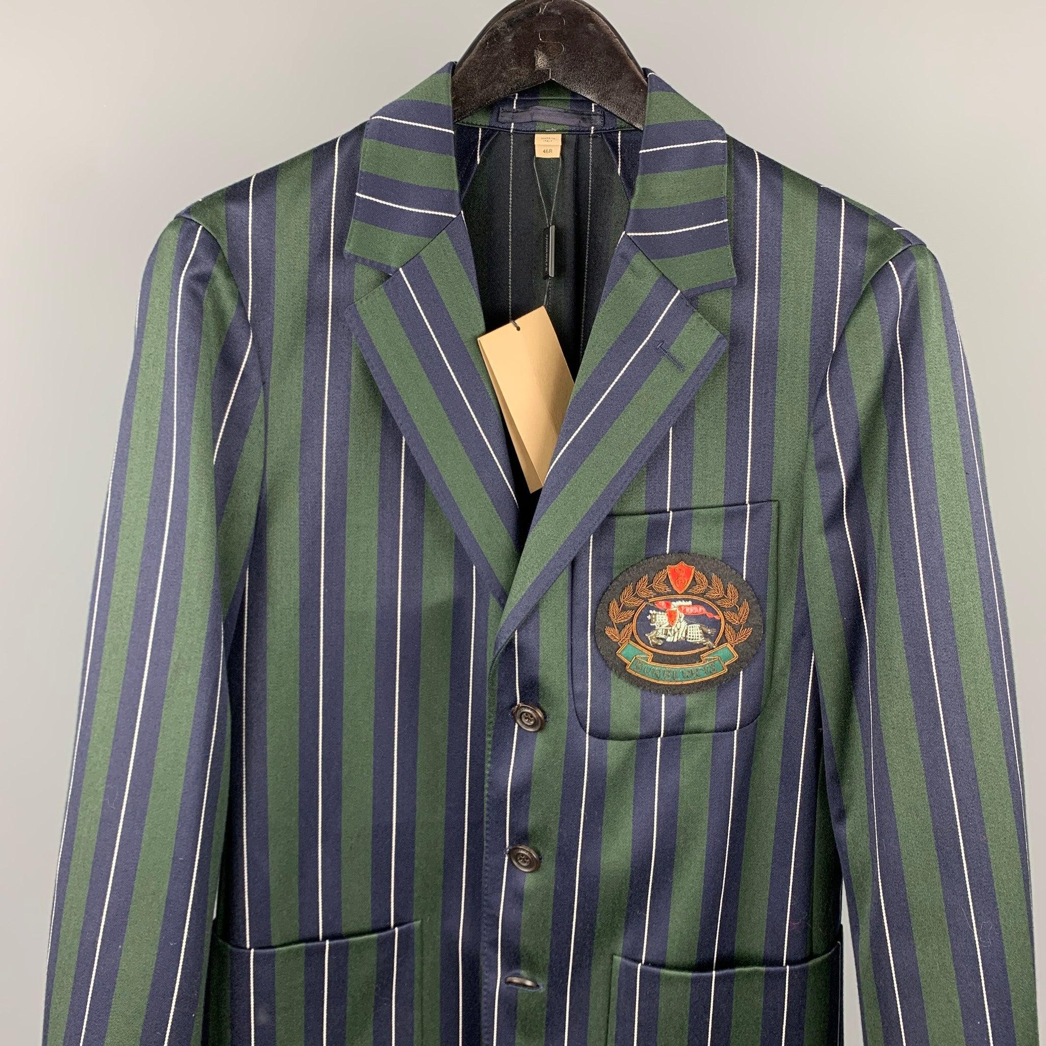 BURBERRY
Anzug aus grüner und marineblauer vertikal gestreifter Wolle/Baumwolle mit halbem Futter und gesticktem Aufnäher auf der Vorderseite, mit einem einreihigen Sportmantel mit drei Knöpfen und einem Revers mit Kerbe sowie einer passenden Hose