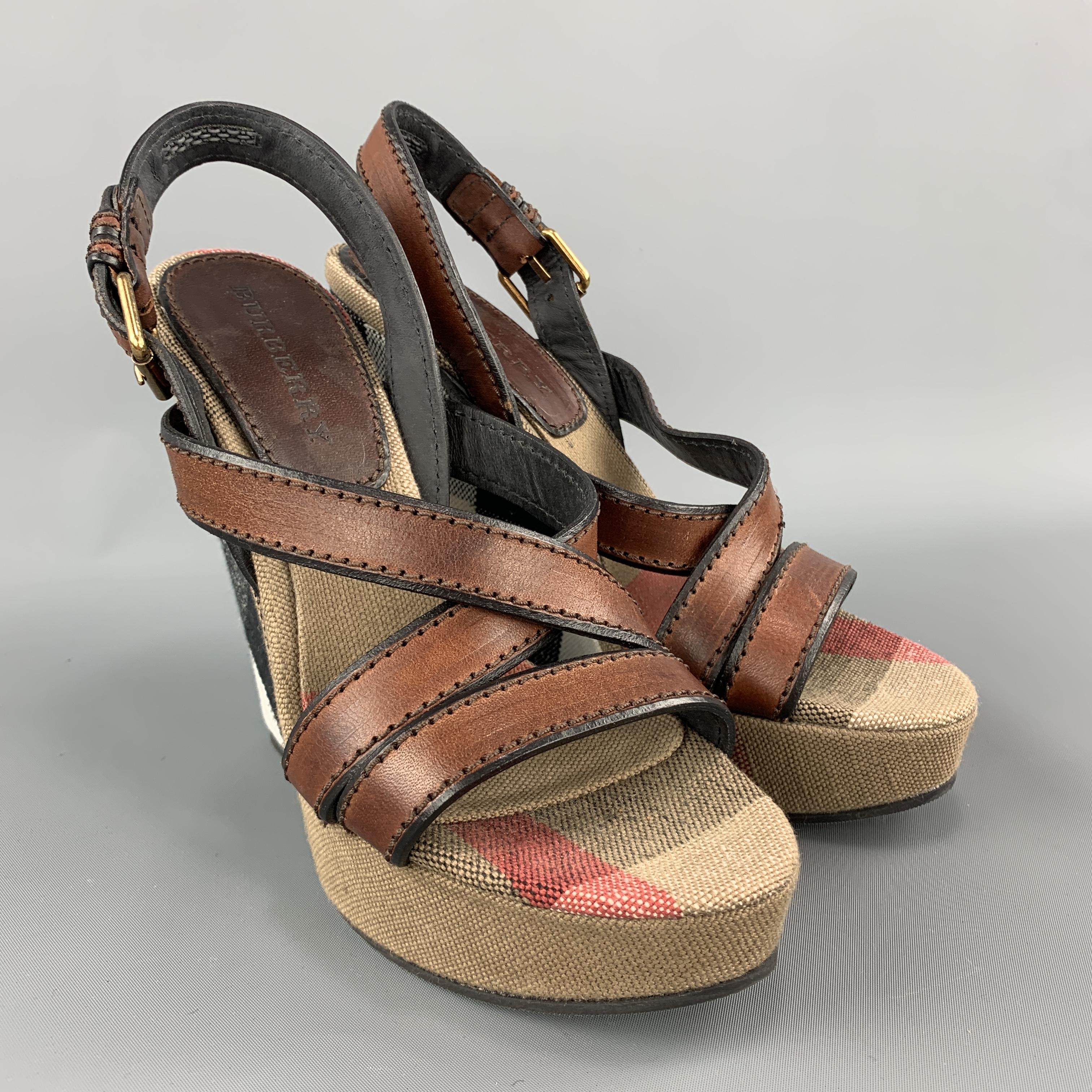 BURBERRY heels feature a signature plaid print canvas covered platform wedge heel and tan leather straps. Made in Italy.

Excellent Pre-Owned Condition.
Marked: IT 39

Heel:5.75 in.
Platform: 1.25 in.