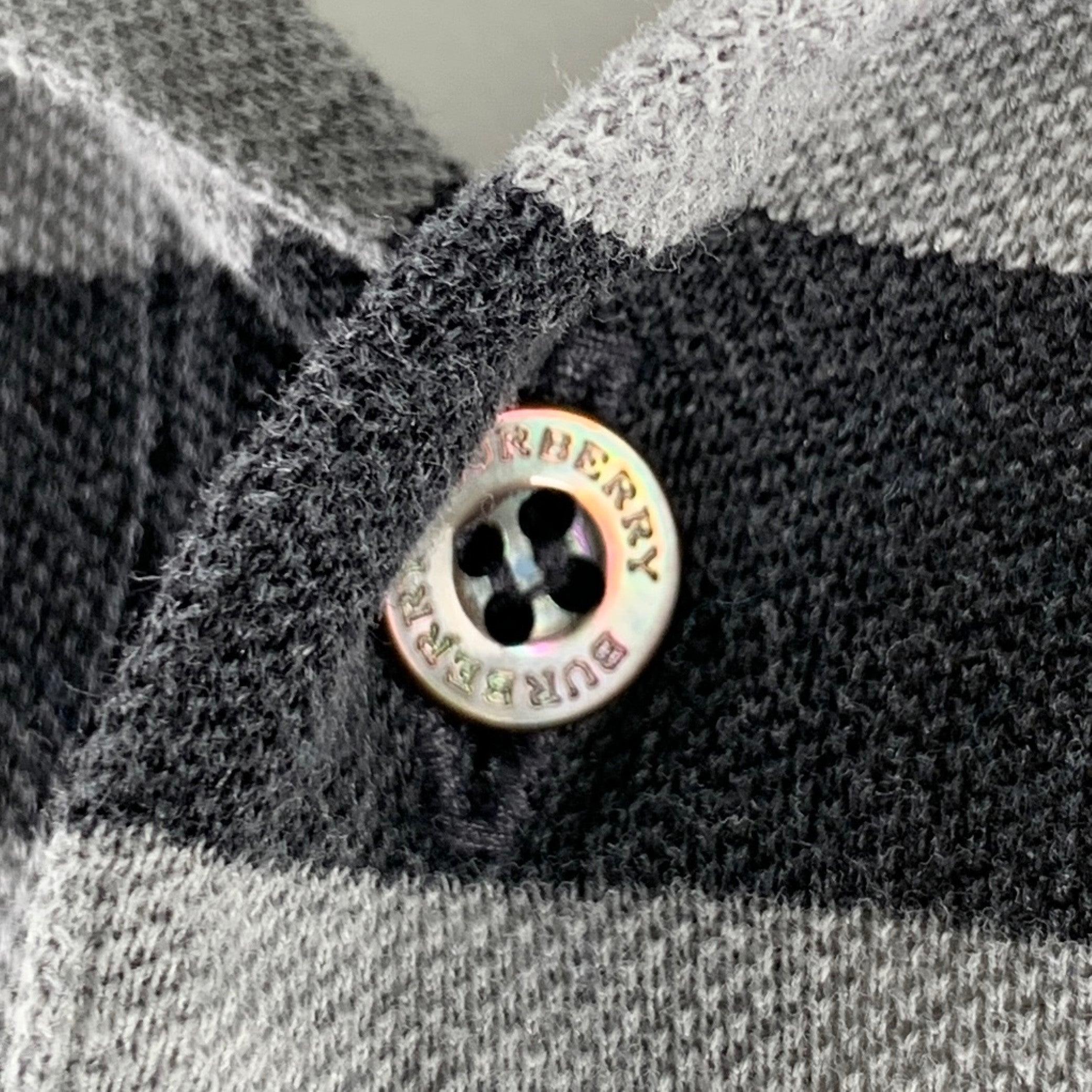 Polo Burberry
in maglia di cotone grigio e grigio antracite con motivo a righe e chiusura con bottoni a metà abbottonatura.Eccellente condizione di usato. 

Contrassegnato:   S 

Misure: 
 
Spalla: 16,5 pollici Petto: 38 pollici Manica: 8,5 pollici