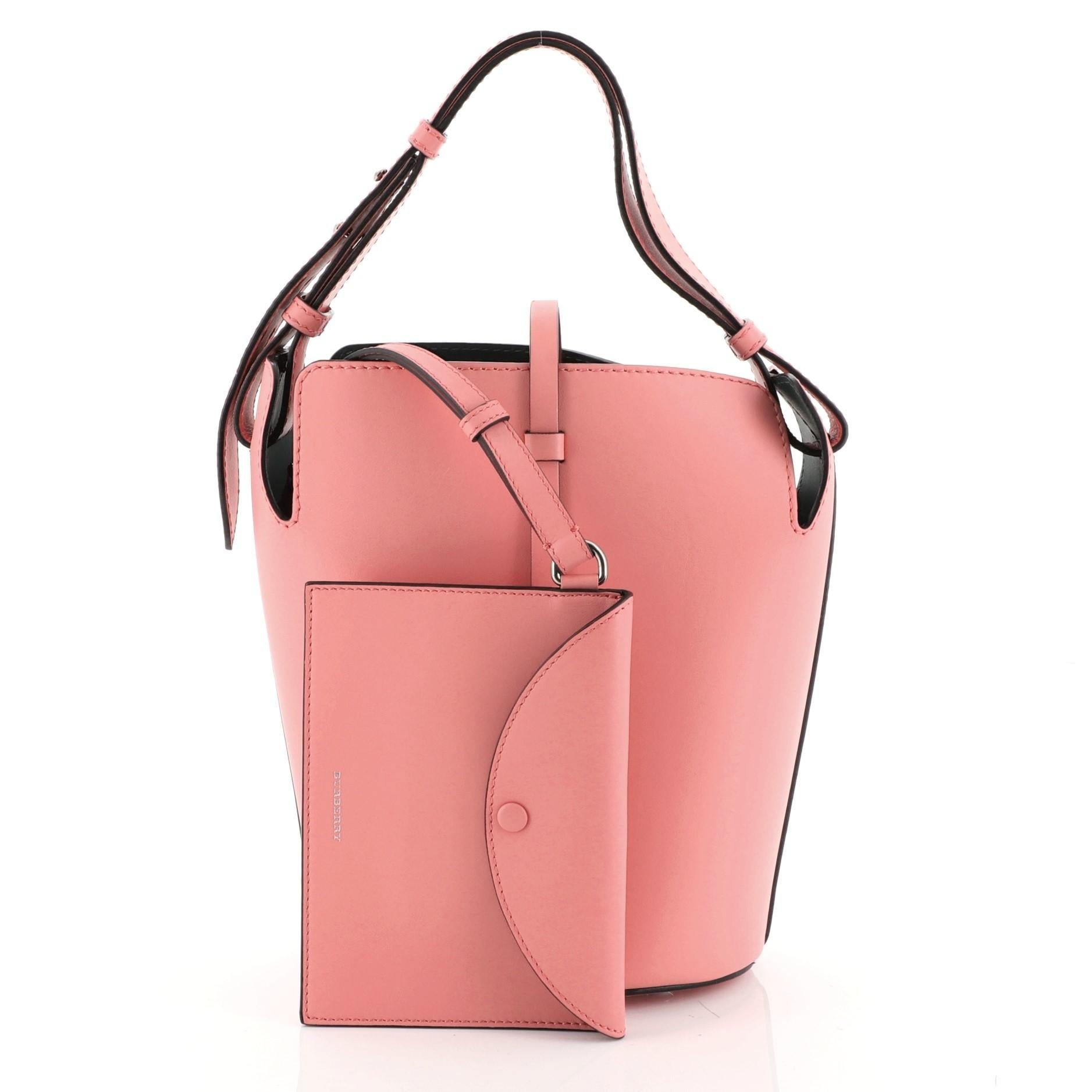 This Burberry Supple Bucket Bag Leather Medium, crafted from pink leather, features adjustable flat shoulder strap and aged silver-tone hardware. It opens to a green leather interior. 

Estimated Retail Price: $1,890
Condition: Great. Faint creasing
