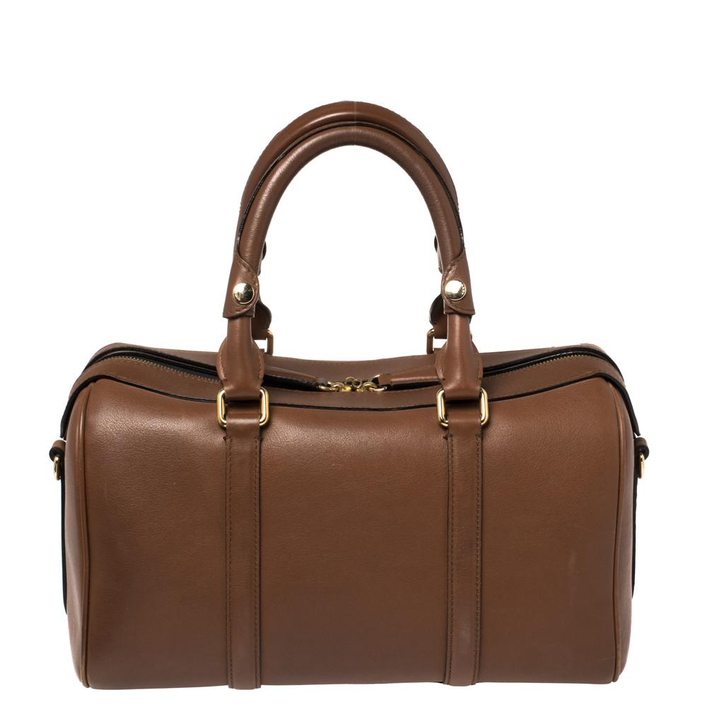 A stunning blend of elegance and luxury, this Burberry bag an instant classic. Ideal for your daily use, this barrel-shaped bag has dual handles and also has an adjustable strap for a hands-free carrying option. The gold-tone hardware perfectly