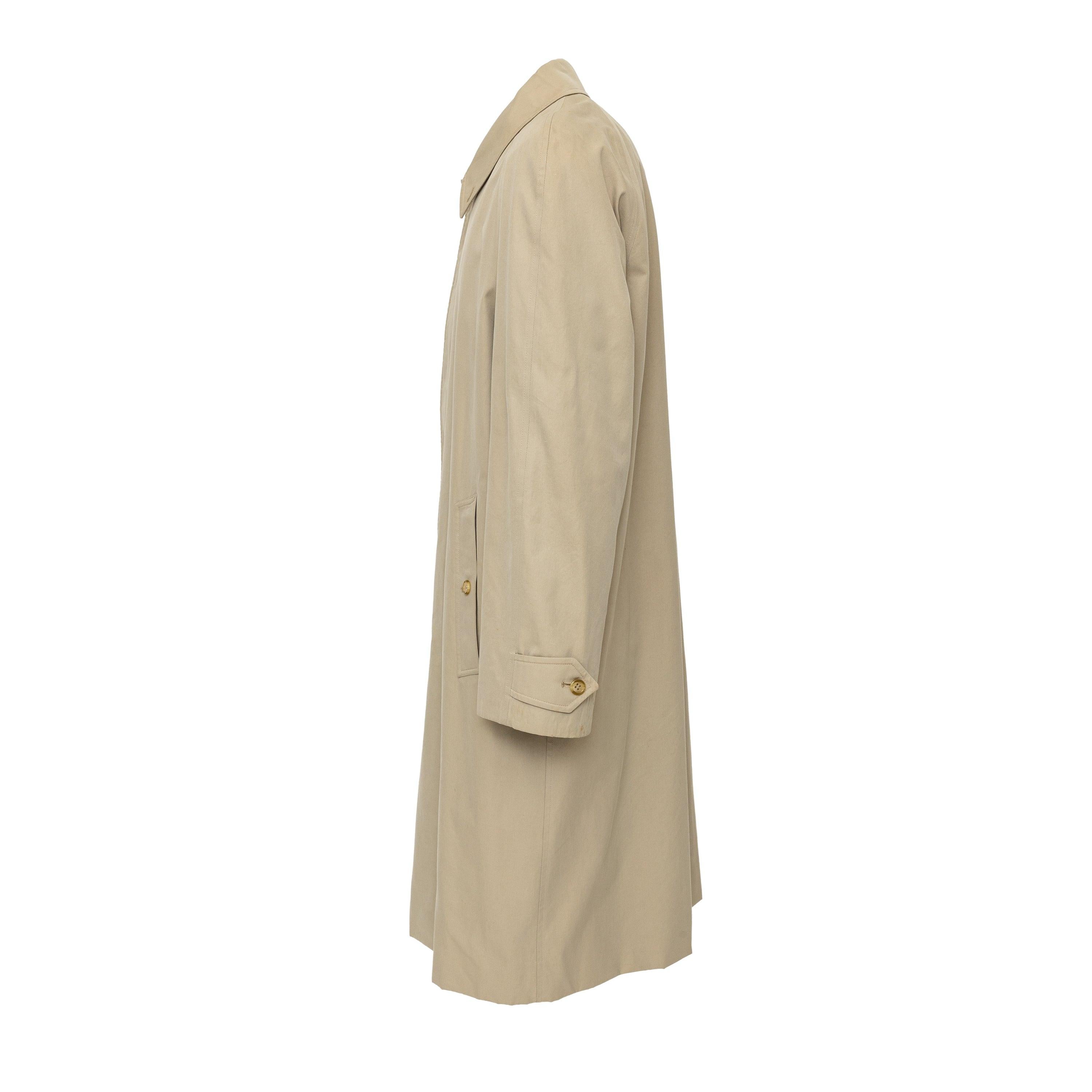 The Burberry Trench Coat in classic beige is a refined statement of classic style. Crafted from durable cotton, it features a collar, one front button with a hidden button stand and the signature check lining. With a relaxed raglan shoulder, it's