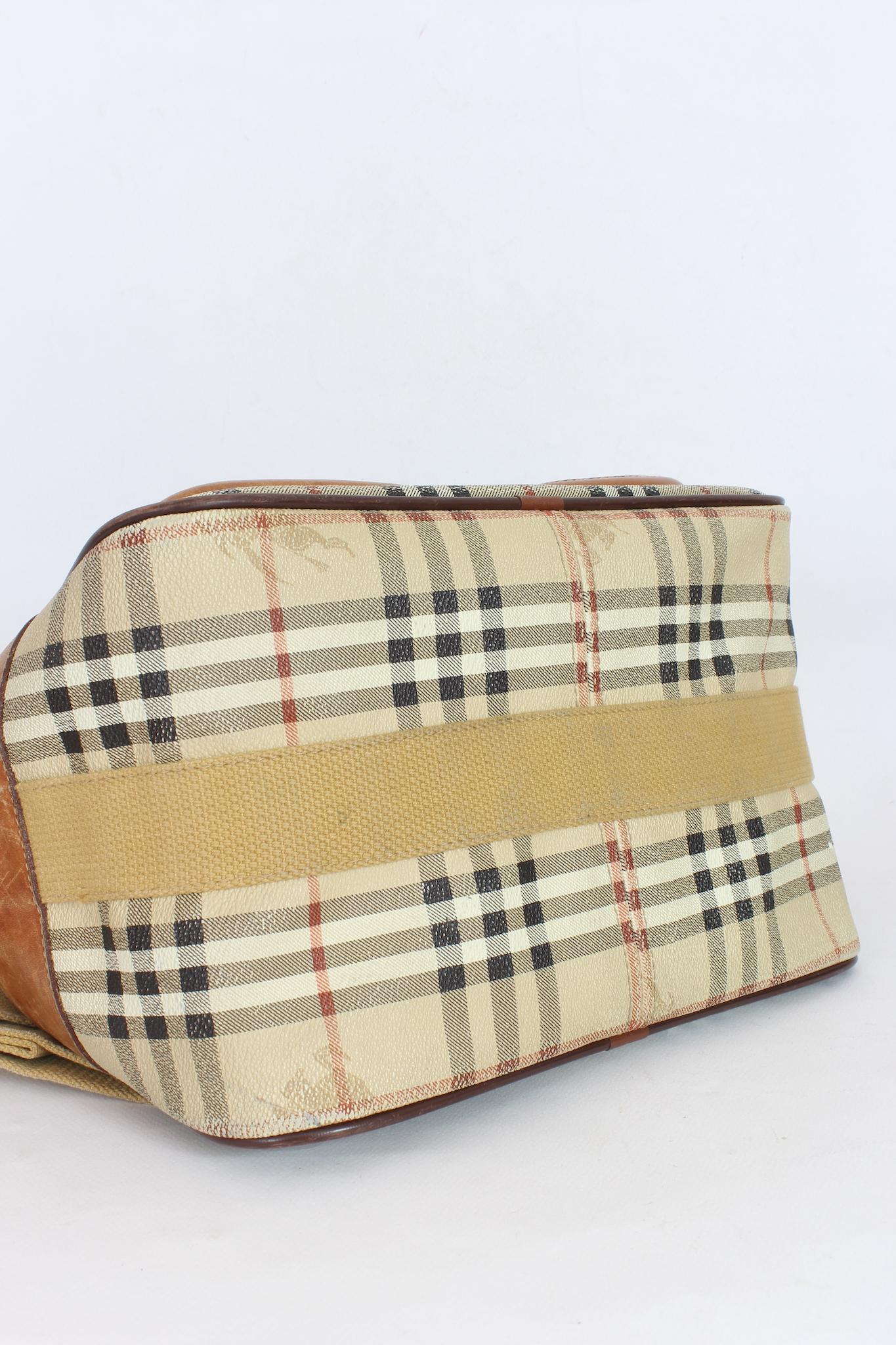 Burberry vintage 80s trunk bag. Shoulder bag with adjustable shoulder strap, beige and brown checked pattern. External pockets, zip and clip button closure. Canvas and leather fabric. Good general condition, there are signs of use.

Height: 28