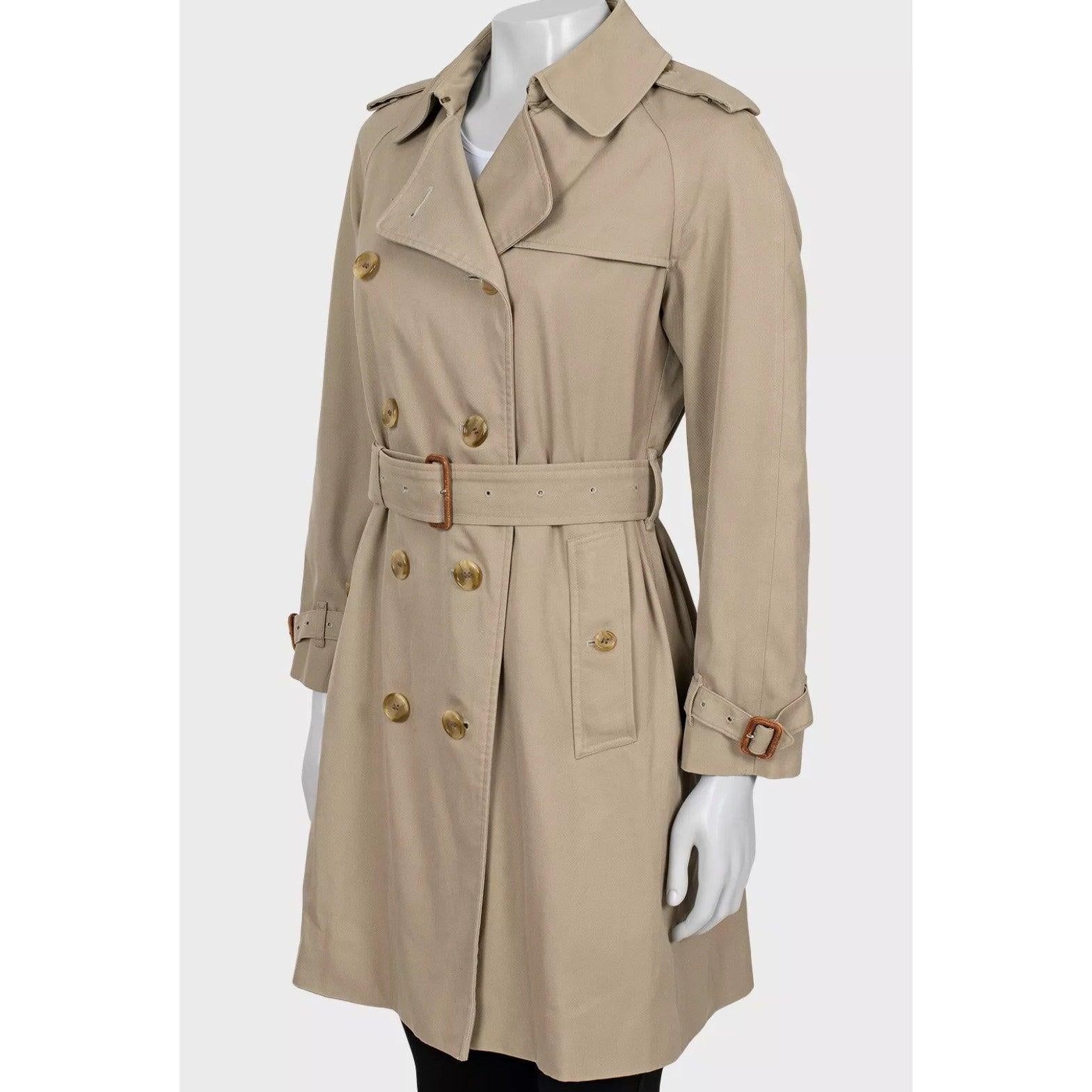 Timeless elegance awaits with this vintage Burberry trench coat. This iconic piece features a classic double-breasted design and button fastening, embodying Burberry's heritage and style.

Crafted from a durable blend of polyester and cotton, with a