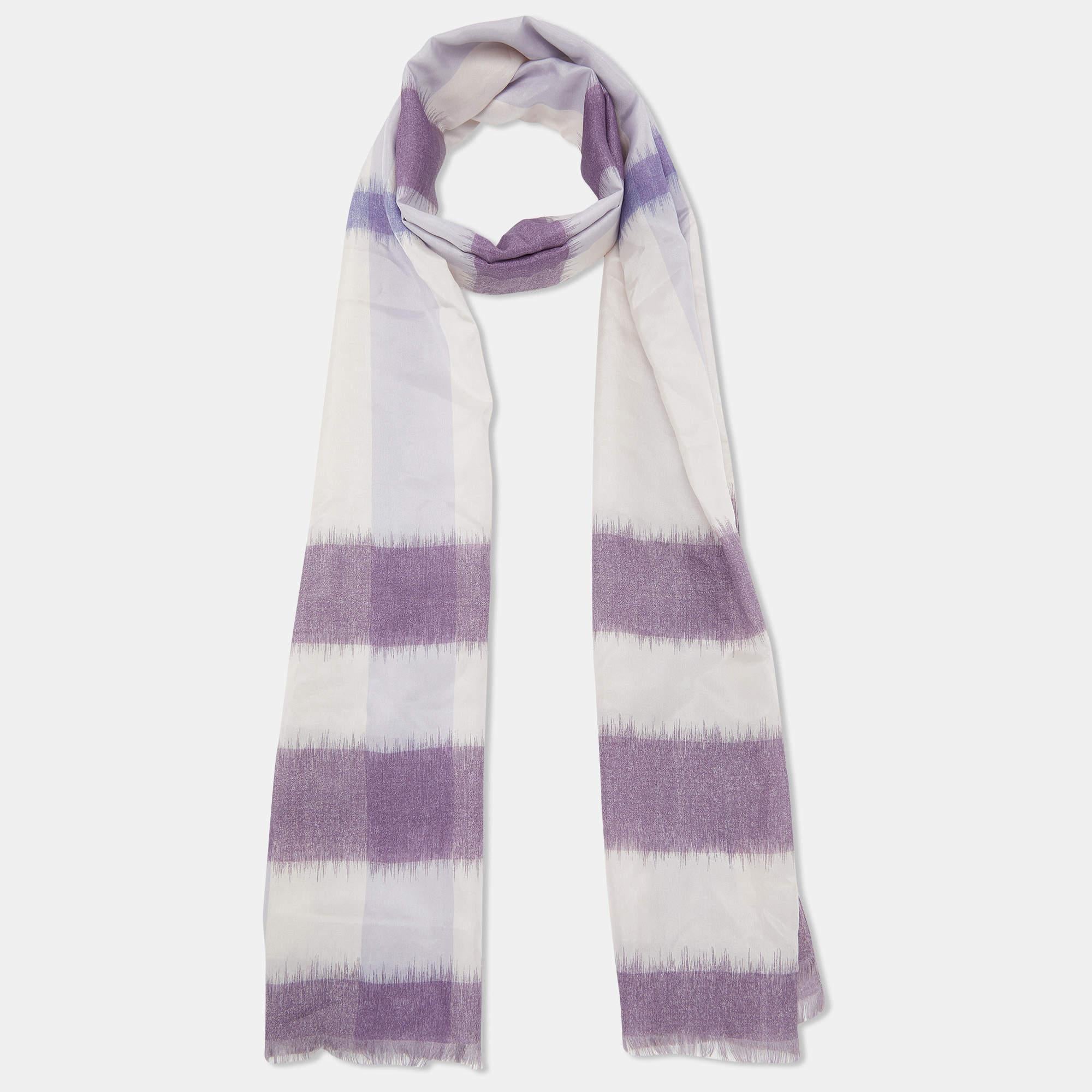 The Burberry scarf boasts a regal hue with an intricate equestrian motif. Crafted in luxurious silk, it features the iconic Horseferry print and elegant fringed edges.

