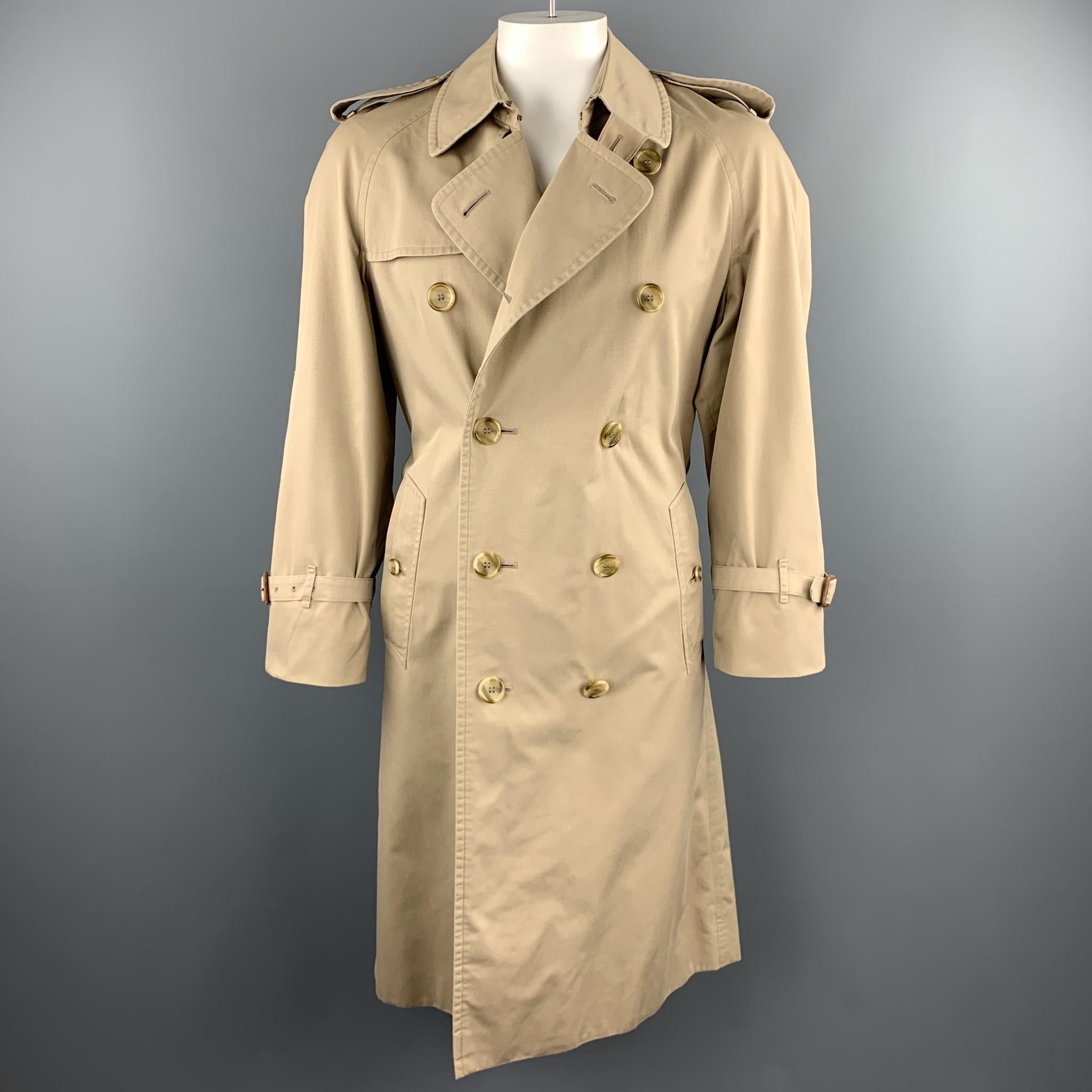 Vintage BURBERRY trench coat comes in classic cotton blend khaki twill with epaulets, double breasted front, raglan belt cuff sleeves, and plaid liner. Made in England.

Very Good Pre-Owned Condition.
Marked: (no size)

Measurements:

Shoulder: 18