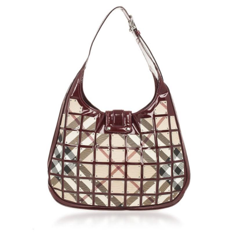 This is not your average Burberry handbag. This Warrior Nova Check ‘Brooke’ is crafted from individual square panels of their iconic check print and patent leather trim. The exterior also features a buckle flap closure and a buckle detailed shoulder