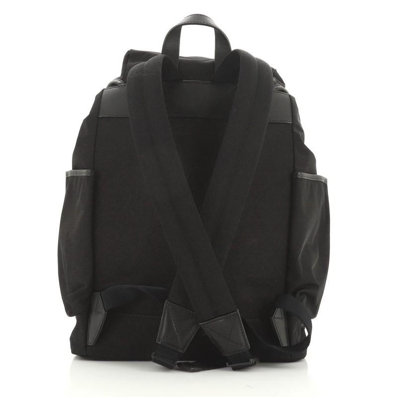 This Burberry Watson Diaper Backpack Nylon Large, crafted from black nylon, features adjustable shoulder straps, top handle, side drawstring pockets, flap top with buckle and black-tone hardware. Its drawstring closure opens to a red nylon