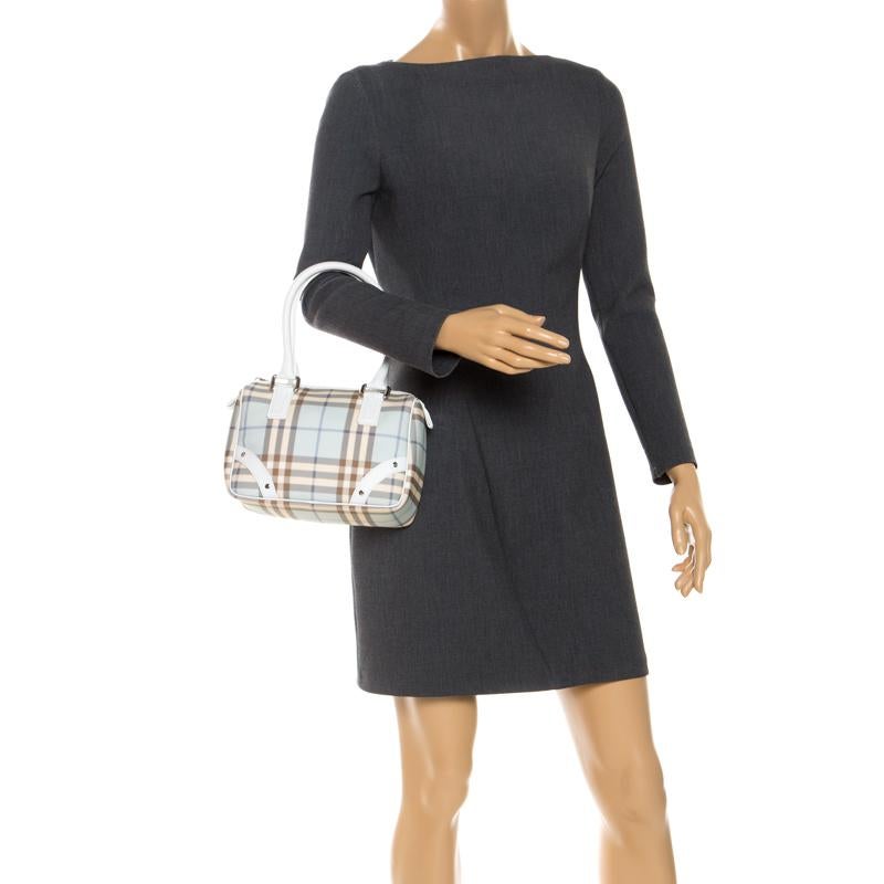 Spacious and captivating, this Chester Boston bag is from Burberry. It has been crafted from their signature Nova Check PVC and accented with white trims and silver-tone hardware. It is equipped with a well-sized nylon interior and two rolled