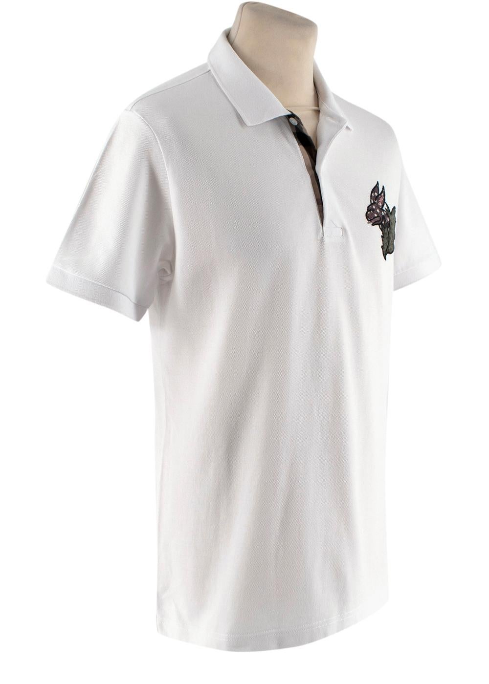 Burberry White Cotton Pique Polo Shirt with Dragon Applique

- White cotton pique polo shirt with ribbed collar, and 2 button fastening
- Cartoon dragon applique on the breast
- Placket revere furnished in signature check
- Slim