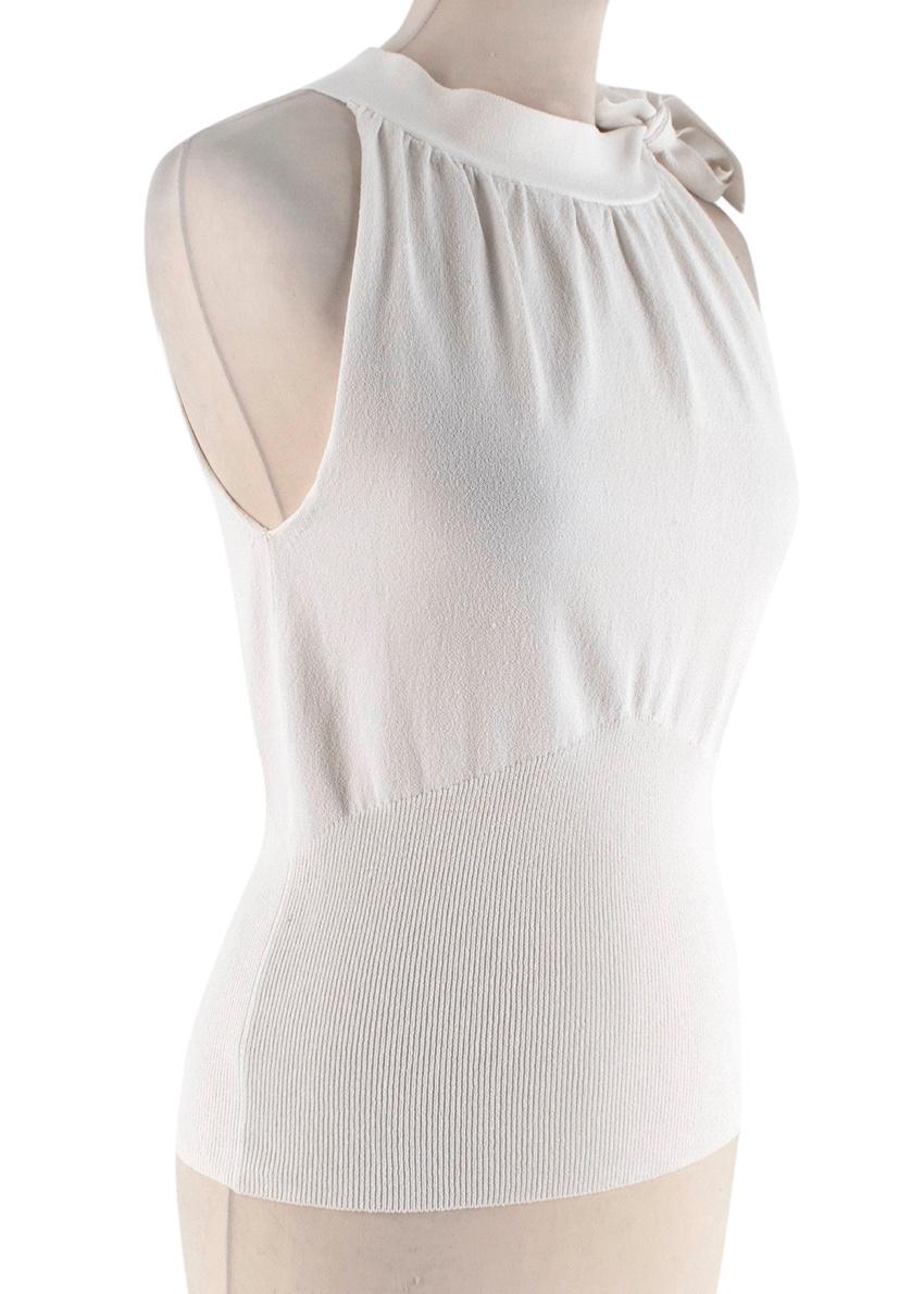 Burberry White Knit Tie Neck Sleeveless Top 

-Soft Knit texture 
-Ribbed detail to the waist 
-Raised collar with ruffled details 
-Bow detail to the shoulder 
-Burberry signature checkered print tag to the side 
-Elegant timeless style
