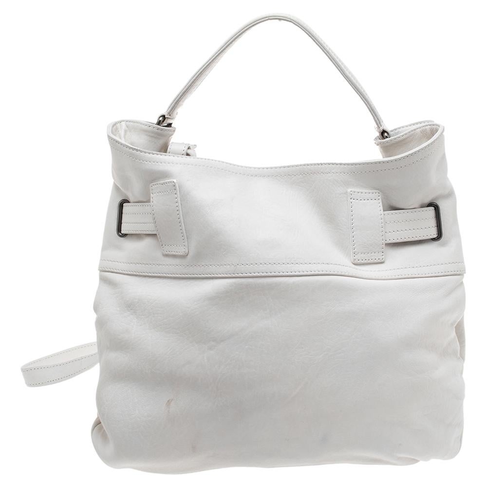 This shoulder bag from Burberry is crafted from white leather. The bag features a belted detail, front pockets, a top handle, an adjustable shoulder strap, and a fabric-lined interior that houses a zip pocket. This creation is easy to carry on any