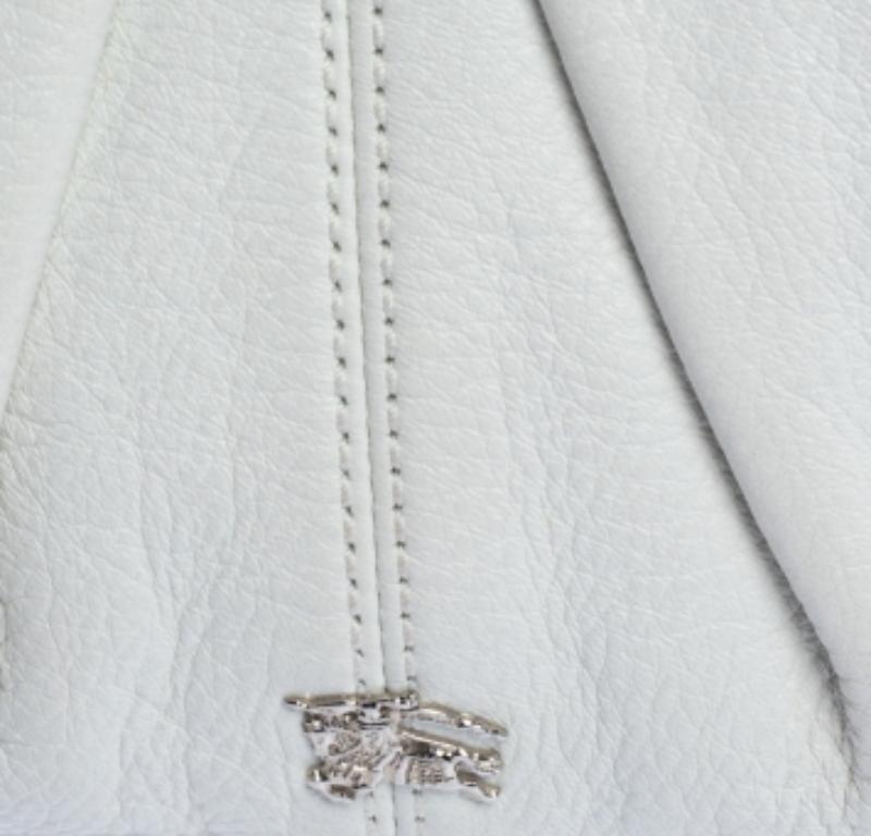 The fashion house of Burberry offers this white hobo bag crafted from high-quality leather for everyday use. Lined with their signature check fabric, it features silver-tone hardware, a single handle, and a rounded base.