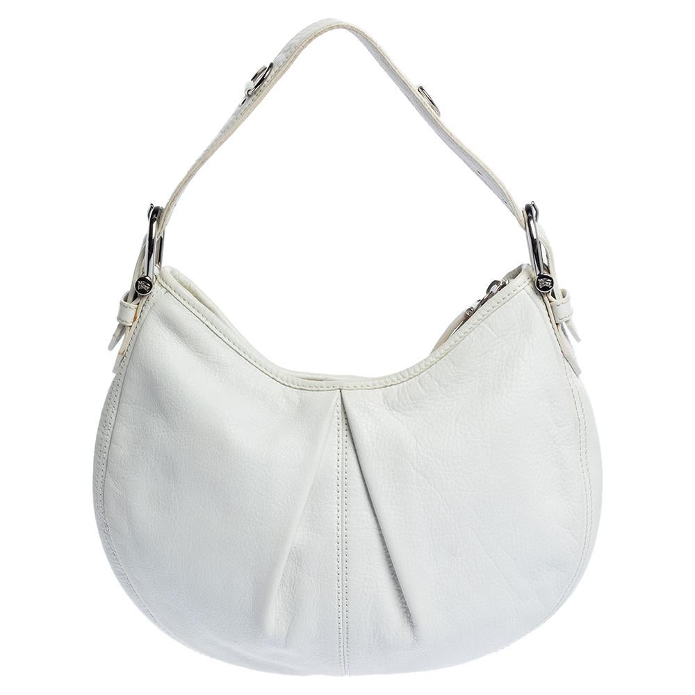 The fashion house of Burberry offers this white hobo bag crafted from high-quality leather for everyday use. Lined with their signature check fabric, it features silver-tone hardware, a single handle, and a rounded base.

