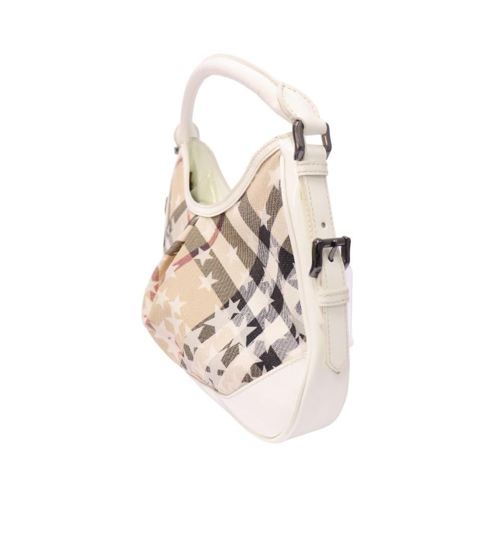 Burberry White Patent Supernova Check Stars Small Hernville Hobo Shoulder Bag, features a fabric interior with one zipper and two slip pockets.
Material: Leather and Canvas
Hardware: Black
Height: 23cm
Width: 30cm
Depth: 5cm
Handle Drop: