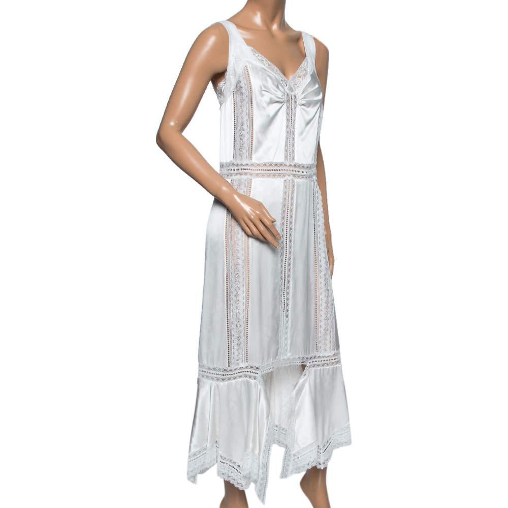 Bring feminine grace and demure to your closet with this beautiful slip dress from the House of Burberry. It is stitched using white satin silk and intricate Chantilly lace. It is accentuated with a steep neckline, a sleeveless style, and an