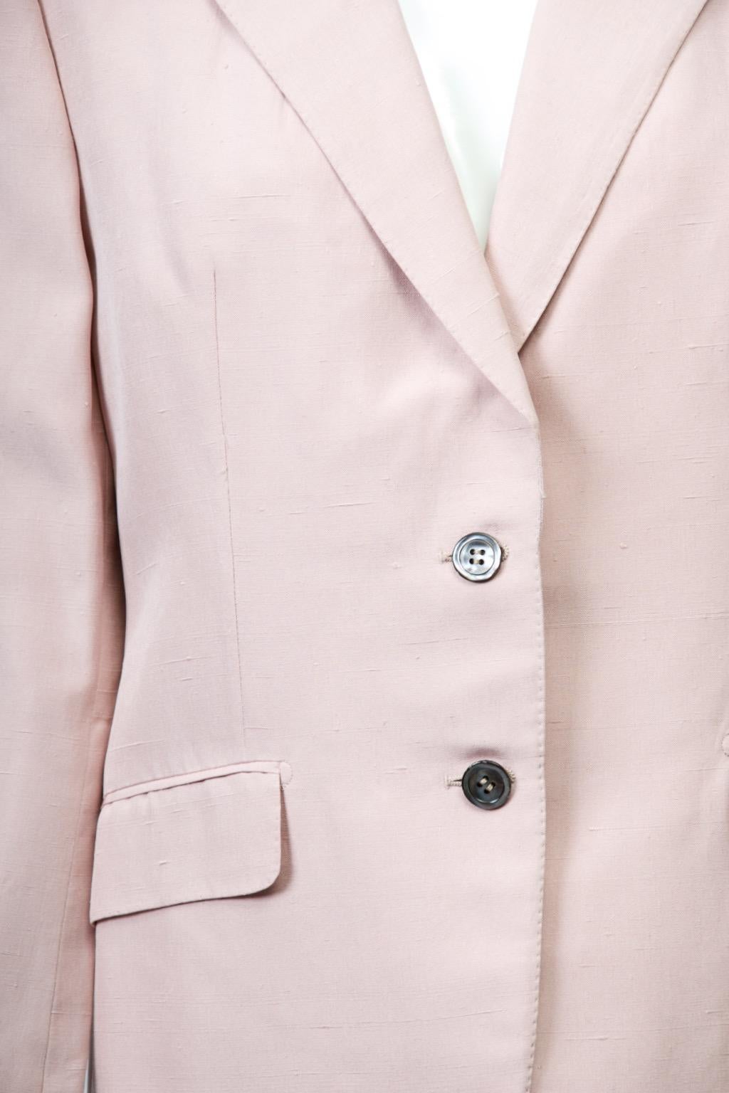 Giacca stile blazer di Burberry in seta rosa, con colletto dentellato e due tasche con patta. I bottoni di perle grigi sul davanti e sui polsini delle maniche dritte offrono un piacevole contrasto.  Cuciture delicate davanti e dietro. Fodera di