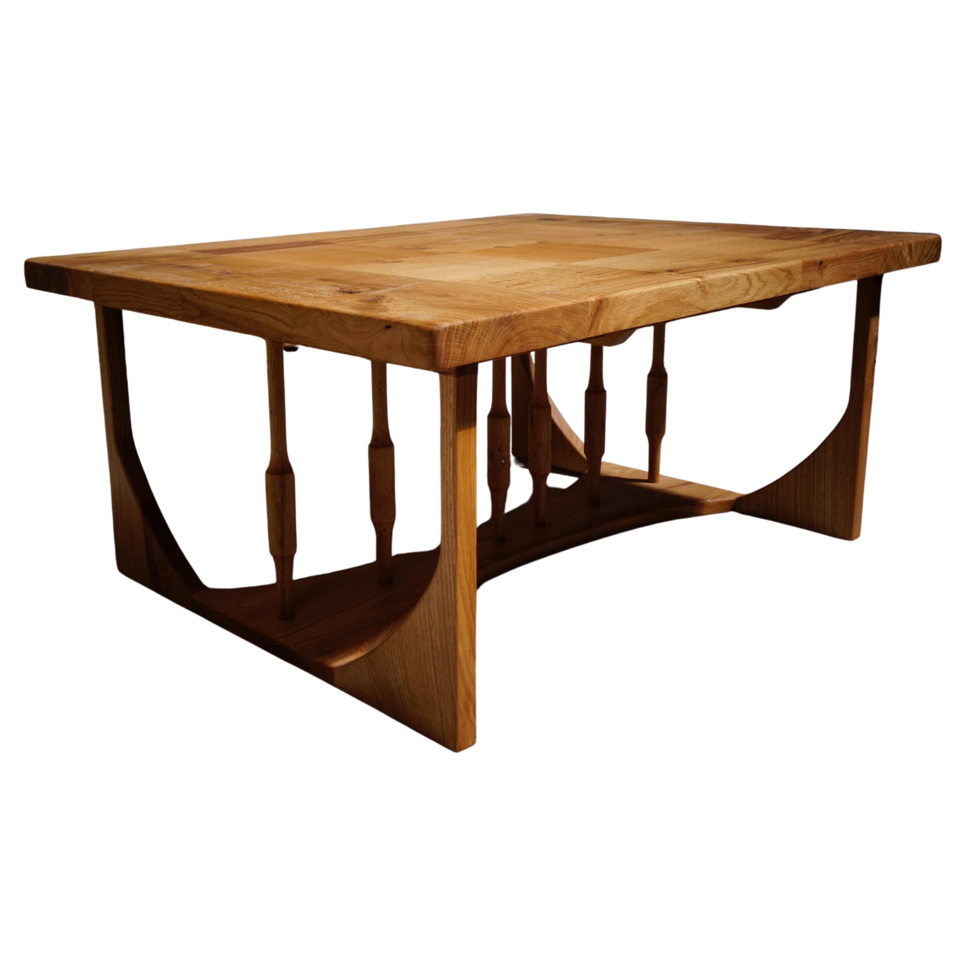 A rectangular coffee table hand made from beautiful French Oak. The table top is made from square tiles orientated with a flowing grain pattern. Vertical spindles add a touch of drama underneath and provide a structural component. Designed to