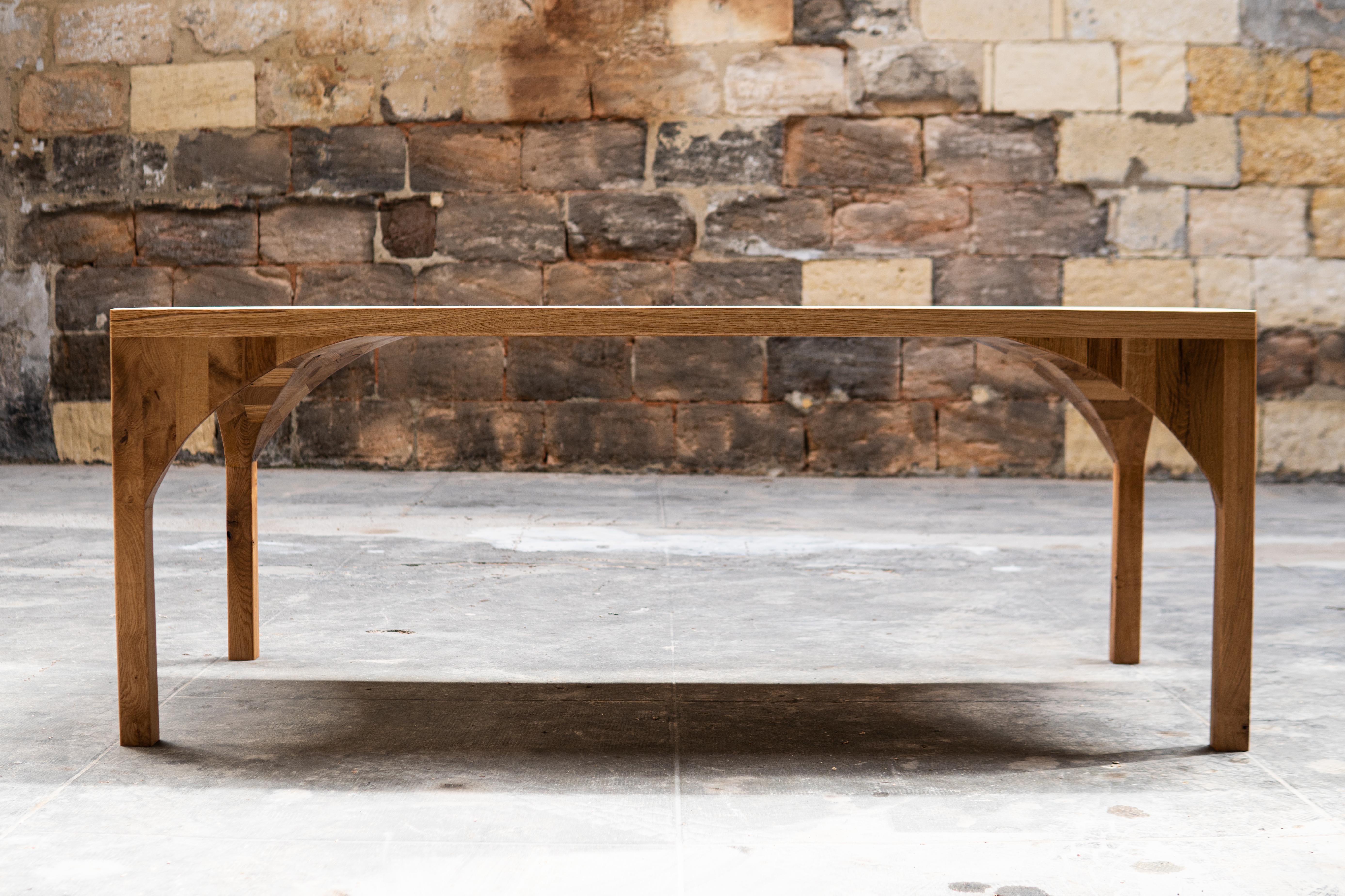 A solid oak dining table for the discerning client. The hand carved soft curves lend an air of subtility to this incredibly strong, rectangular dining table. The legs flow into arched forms that are all connected to the table top to act as one,