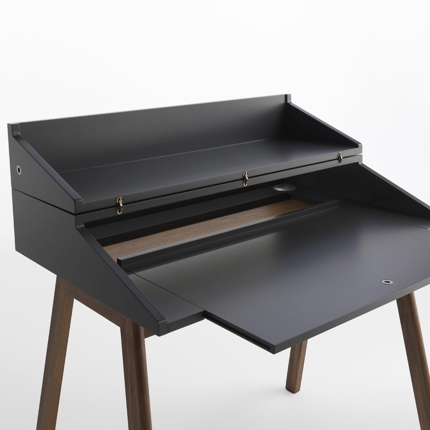 Functional and elegant at once, this writing desk boasts a modern and versatile allure. Designed by Esa Vesman, it is crafted of Canaletto walnut wood with a black lacquer finish and features a hutch in MDF that closes down to keep things on the