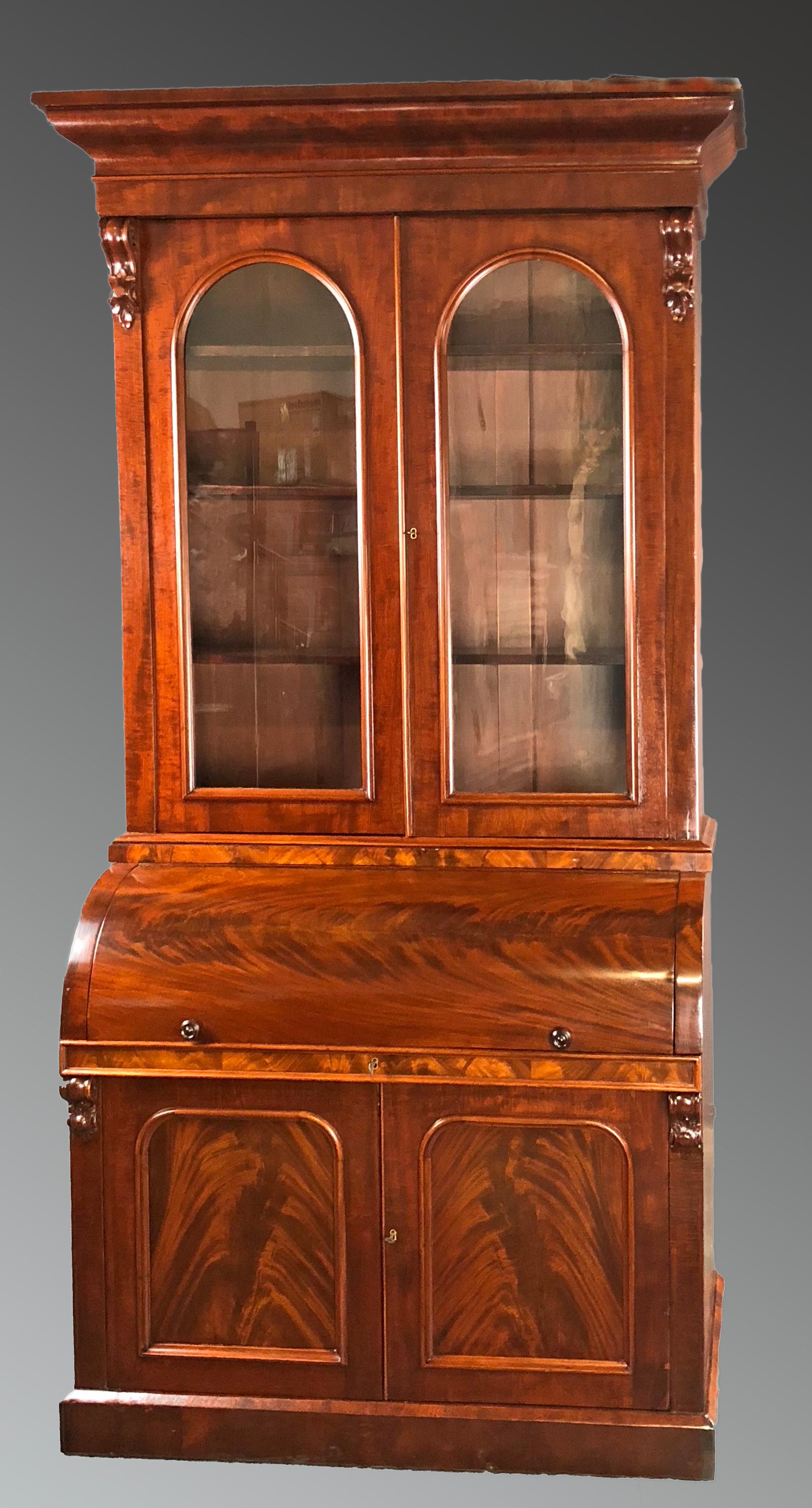 Bureau bookcase dating to the second half of the 19th century of English origin featuring the finest figured mahogany veneers. The cylinder top bureau once open, it reveals a series of compartments and small drawers with attractive bird's-eye maple