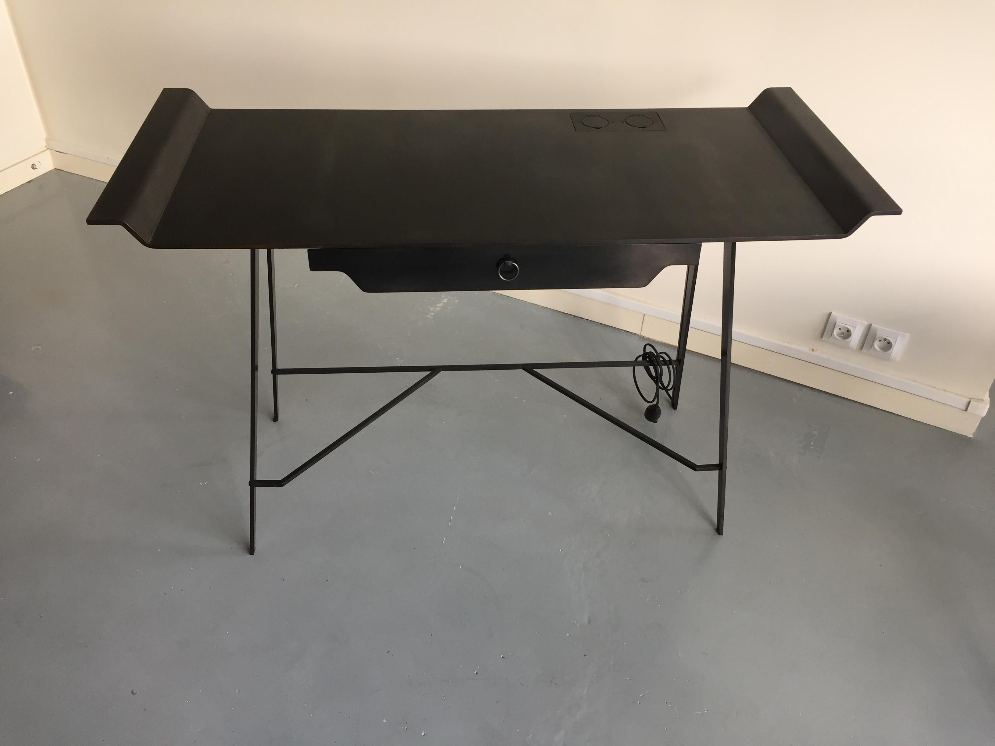  Bureau de Marie-hélène clin
Très graphique,  de forme légère malgré le poids de ce plateau en acier de 8mm d'épaisseur .
Mais son atout principal est de disposer de 2 prises électriques intégrées dans son plateau  qui vous permettent de brancher