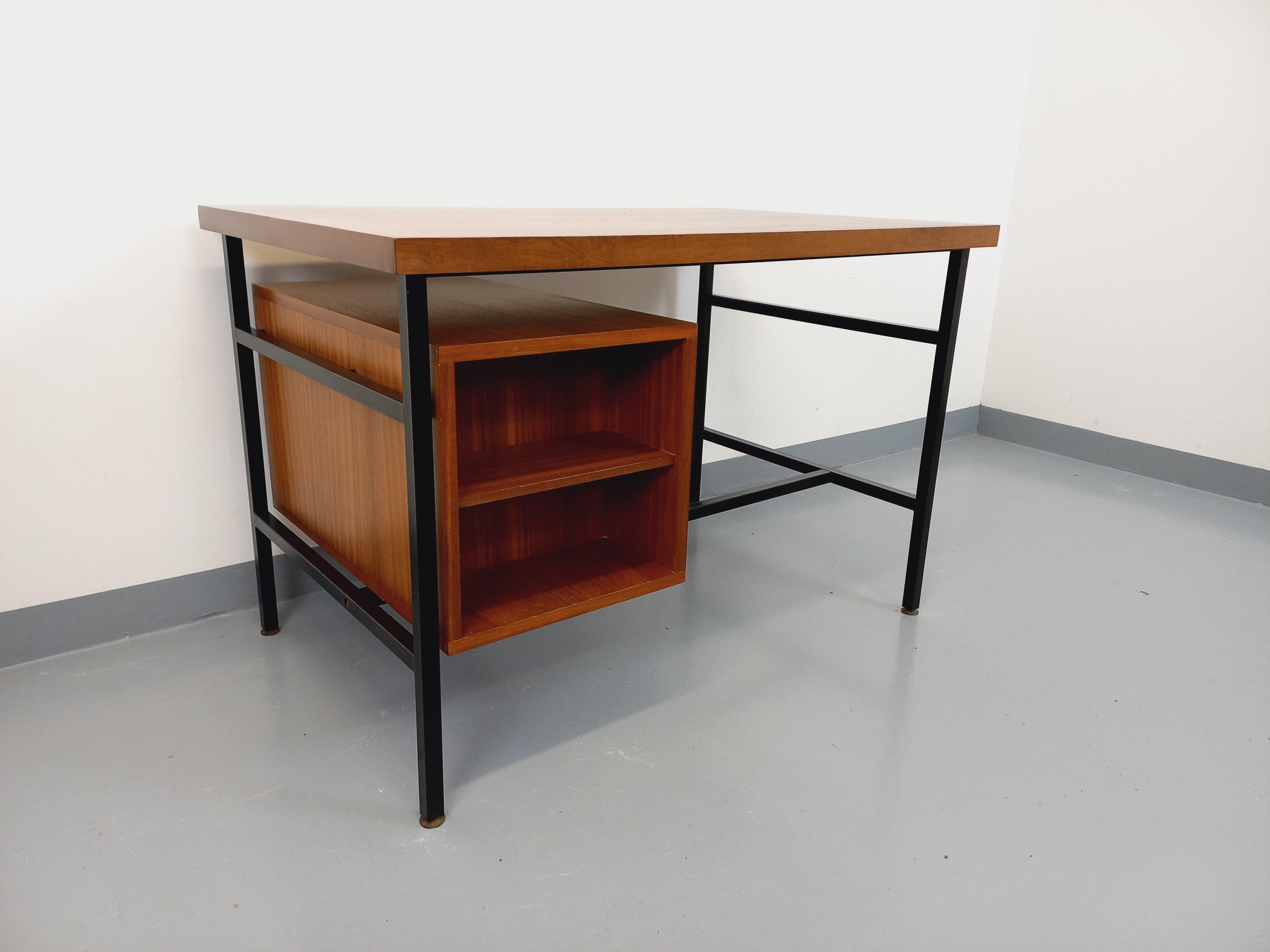 Bureau vintage des années 60, double-face pour être placé au centre d'une pièce, style moderniste dans le goût de Pierre Guariche ou By, en bois d'acajou, profond plateau, piétement métallique noir, caisson avec 3 tiroirs et poignées en bois noir,