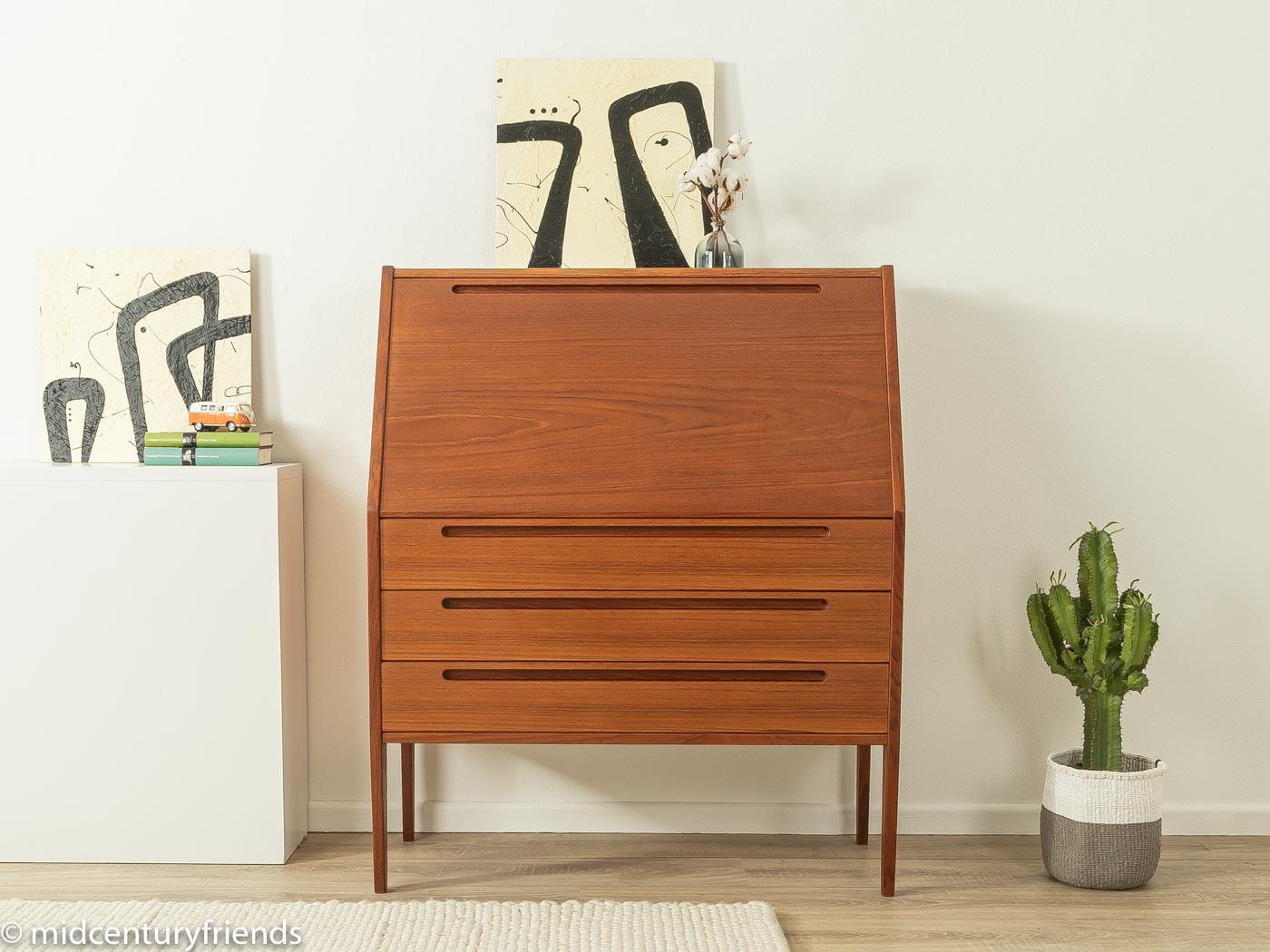 Rare bureau from the 1960s by Nils Jonsson for HJN Møbelfabrik. Corpus in teak veneer with a hinged work surface, three large and three small drawers, one of which has a mirror, two storage compartments and straight feet. The interior can be
