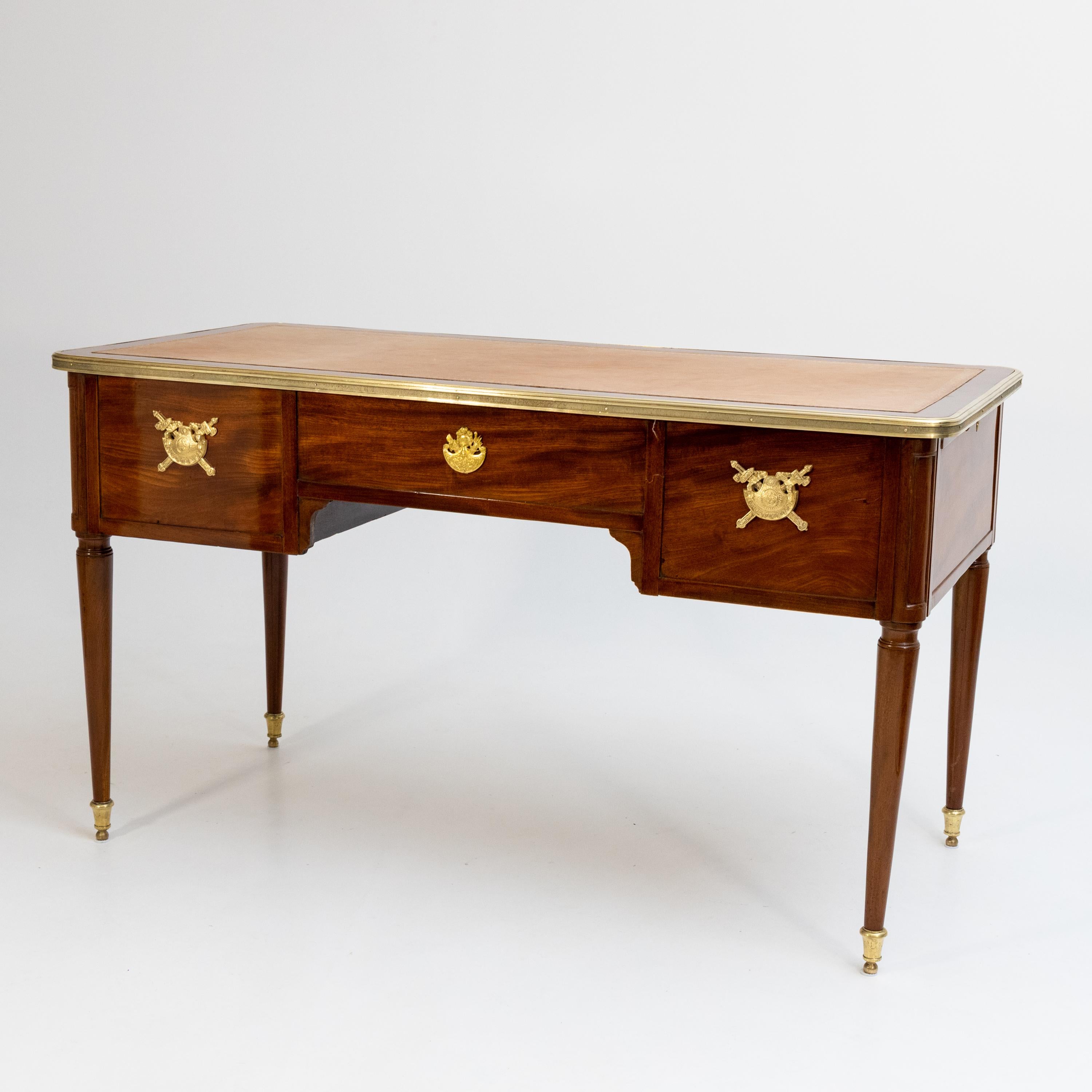 Bureau Plat on conical pointed legs with brass sabots and leather-covered tabletop. The front is divided into four drawers - the right one has an insert and a secret compartment. The back is designed to correspond to the front.