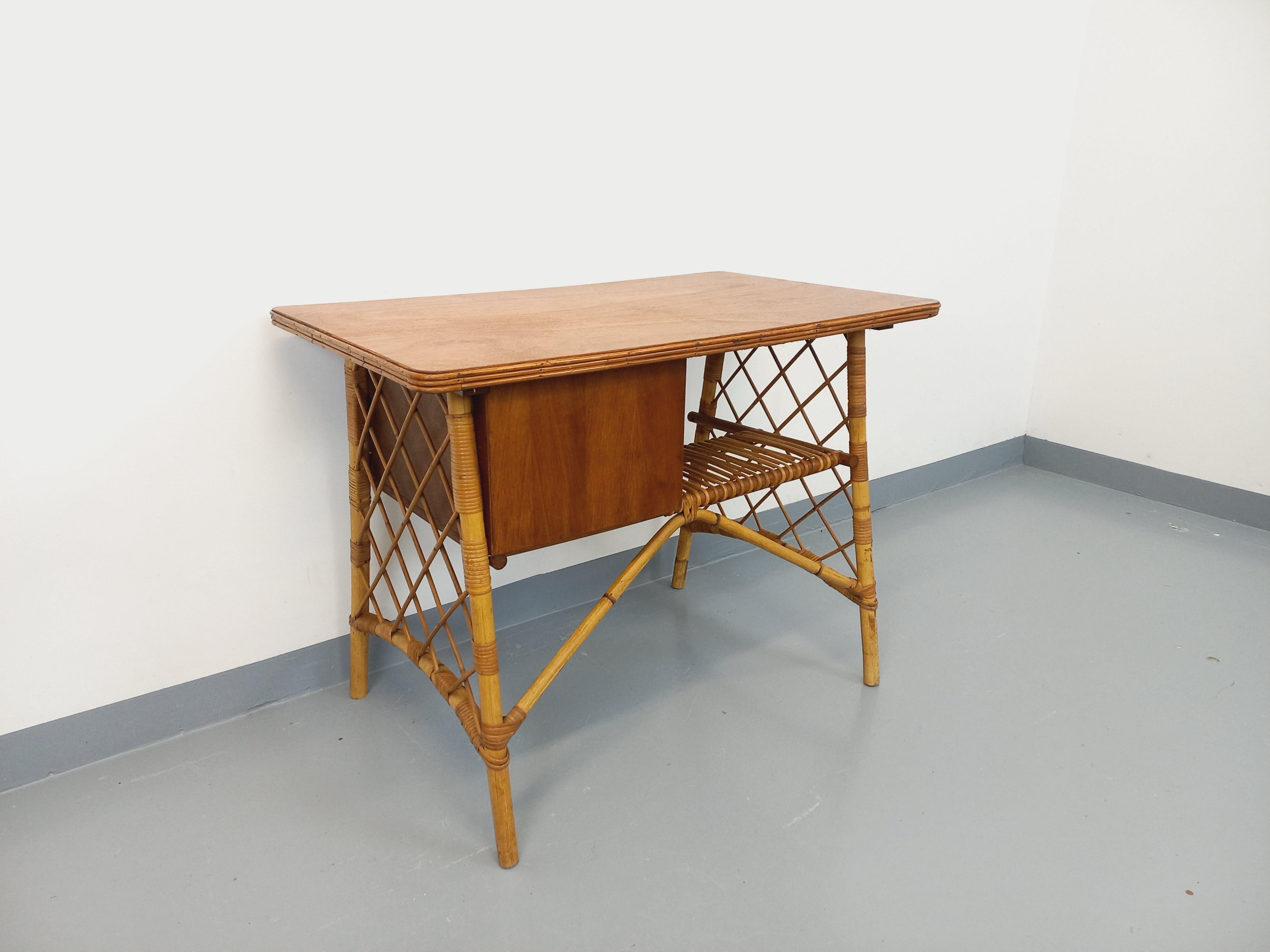 Bureau vintage des années 60, très joli design attribué à Louis Sognot, en rotin, plateau et tiroirs en bois de chêne, 3 tiroirs, très beau travail du rotin, très bon état général avec patine du temps qui passe. Es kann in der Mitte eines Raumes