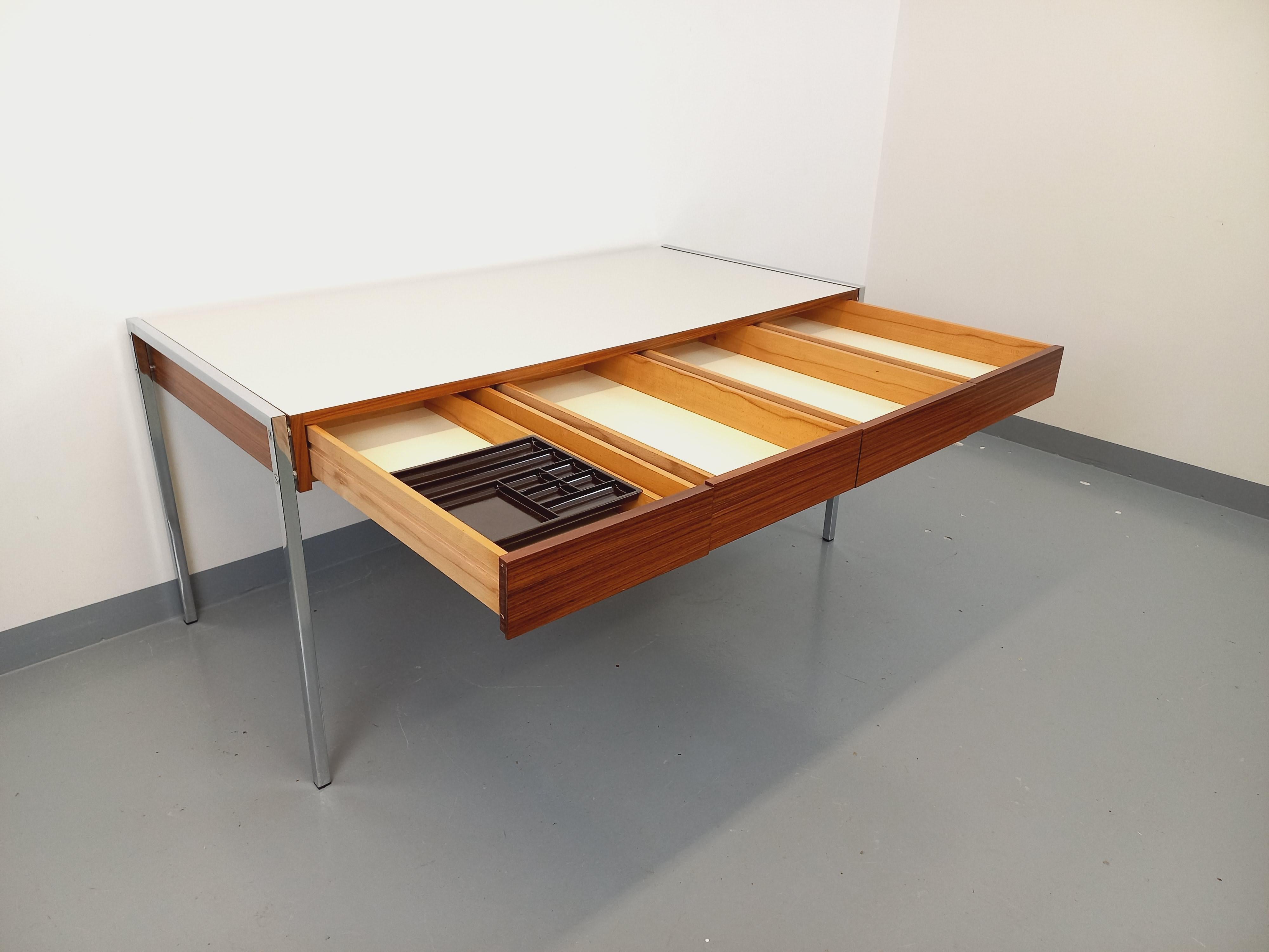 Bureau vintage des années 60 70, style moderniste, design dans le goût de Joseph-André Motte, Georges Frydman, Florence Knoll ou Pierre Paulin, en palissandre, plateau en mélaminé blanc crème, piétement en métal chromé, 4 tiroirs de rangement très