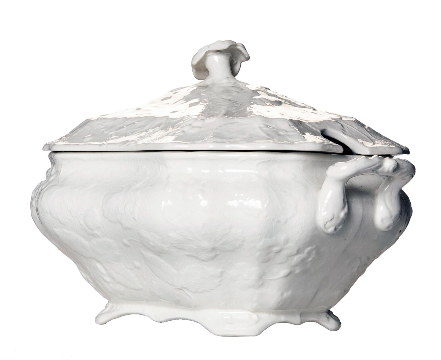 Burgess & Leigh Ironstone soup tureen with white strawberry & grape leaf pattern.
The lid has an opening for a ladle & flower topped on the lid for lifting off the lid.


