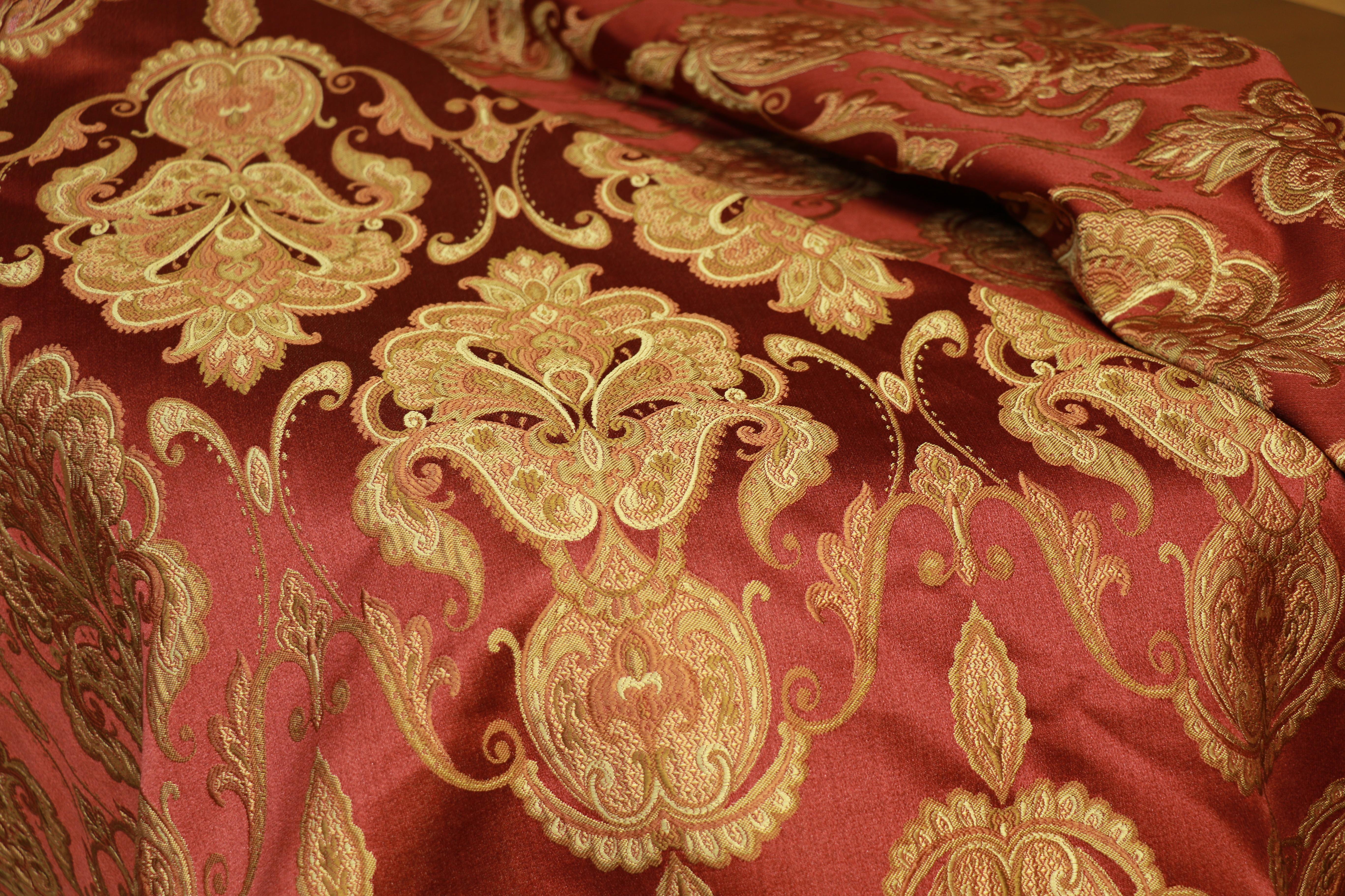 Si tratta di una bellissima tovaglia con motivo jacquard nei colori bordeaux e oro. Questo proviene da una collezione di tovaglie vendute all'asta, oggetti di scena provenienti dai Warner Brothers Studios di Burbank, in California, e venduti a