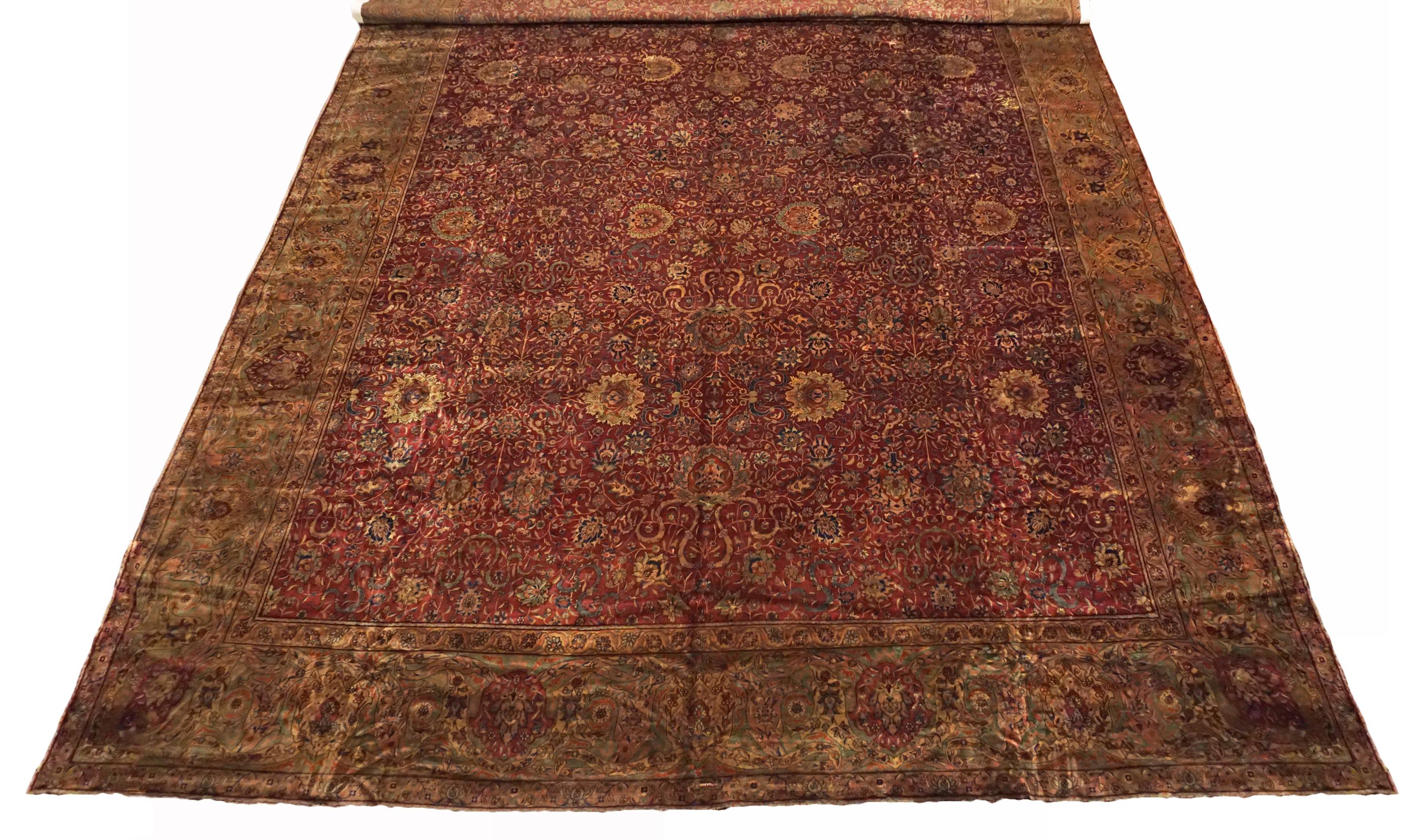 Handgeknüpfter Wollflor auf einem Baumwollgrund.

CIRCA 1900 

Abmessungen: 17'8'' x 24'3'' 

Herkunft: Indien 

Bedingung: Verringert 

Feldfarbe: Burgunderrot 

Farbe der Umrandung: Hunter-Green 

Akzentfarben: Hellbraun, Kupfer,
