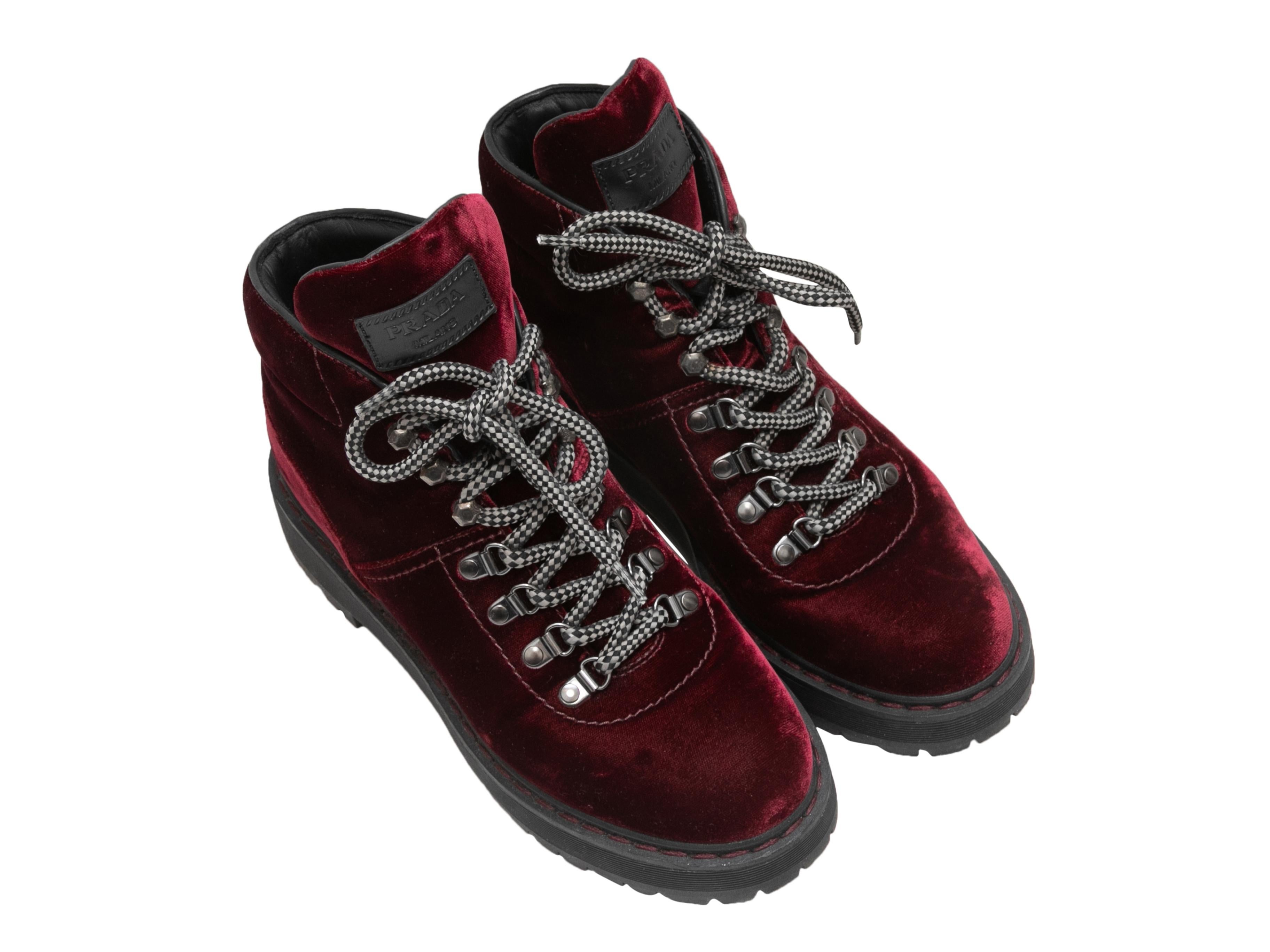  Burgundy and black velvet combat boots by Prada. Rubber lug soles. Lace-up tie closures at tops. 4.5