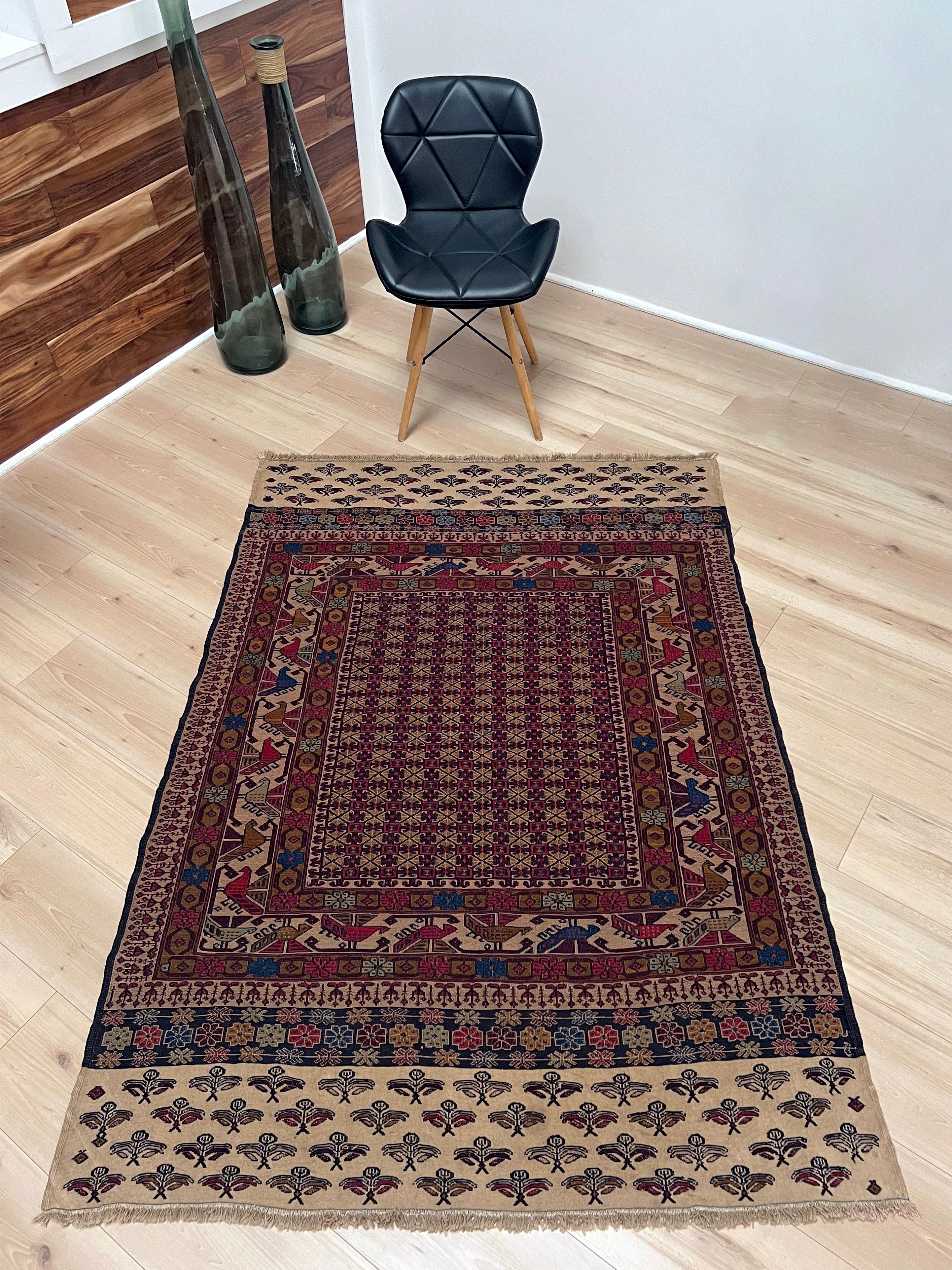 Handwoven in the Caucasus, this vintage Armenian Soumak rug showcases an extraordinary level of craftsmanship and storytelling. Its field is packed with intricate repeating motifs in deep burgundy, navy blue, honey gold, soft camel, and ivory, all