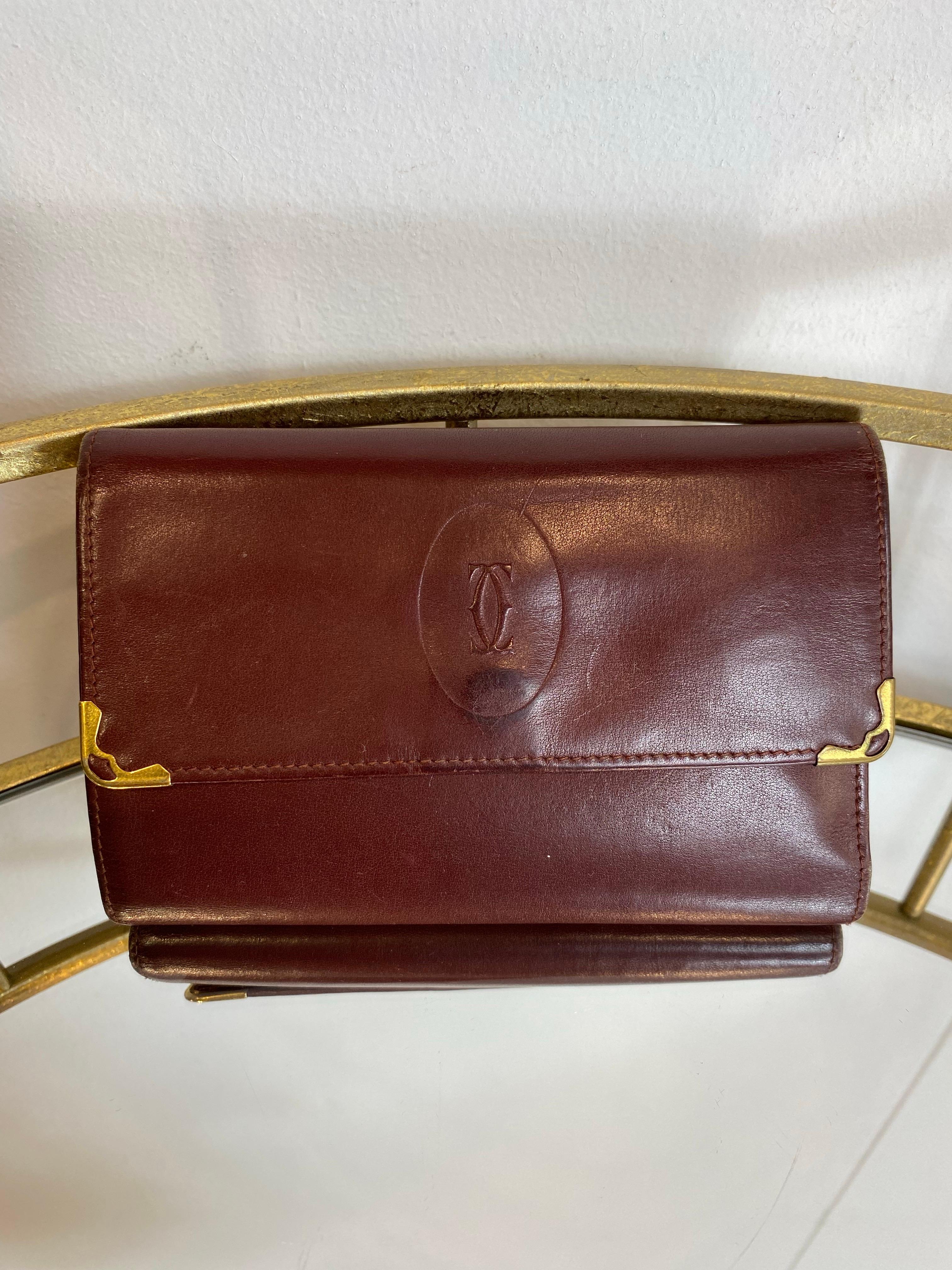 Burgundy Cartier wallet.
Shows signs of use as shown in the photos but overall in good condition.

Width 14 cm
Height 10 cm
Depth 2 cm