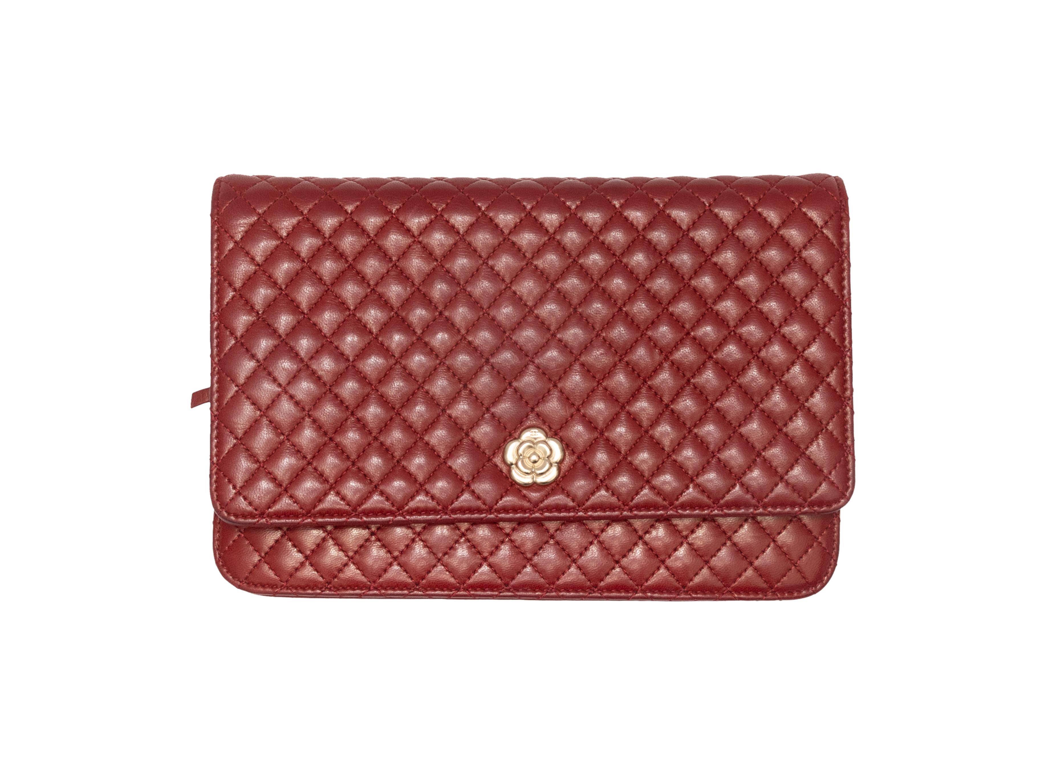 Burgundy Chanel 2008-2009 Micro Camellia Flap Bag. The Micro Camellia Bag features a quilted leather body, gold-tone hardware, multiple interior card and cash slots, an exterior back pocket, a single chain-link and leather strap, and a front flap