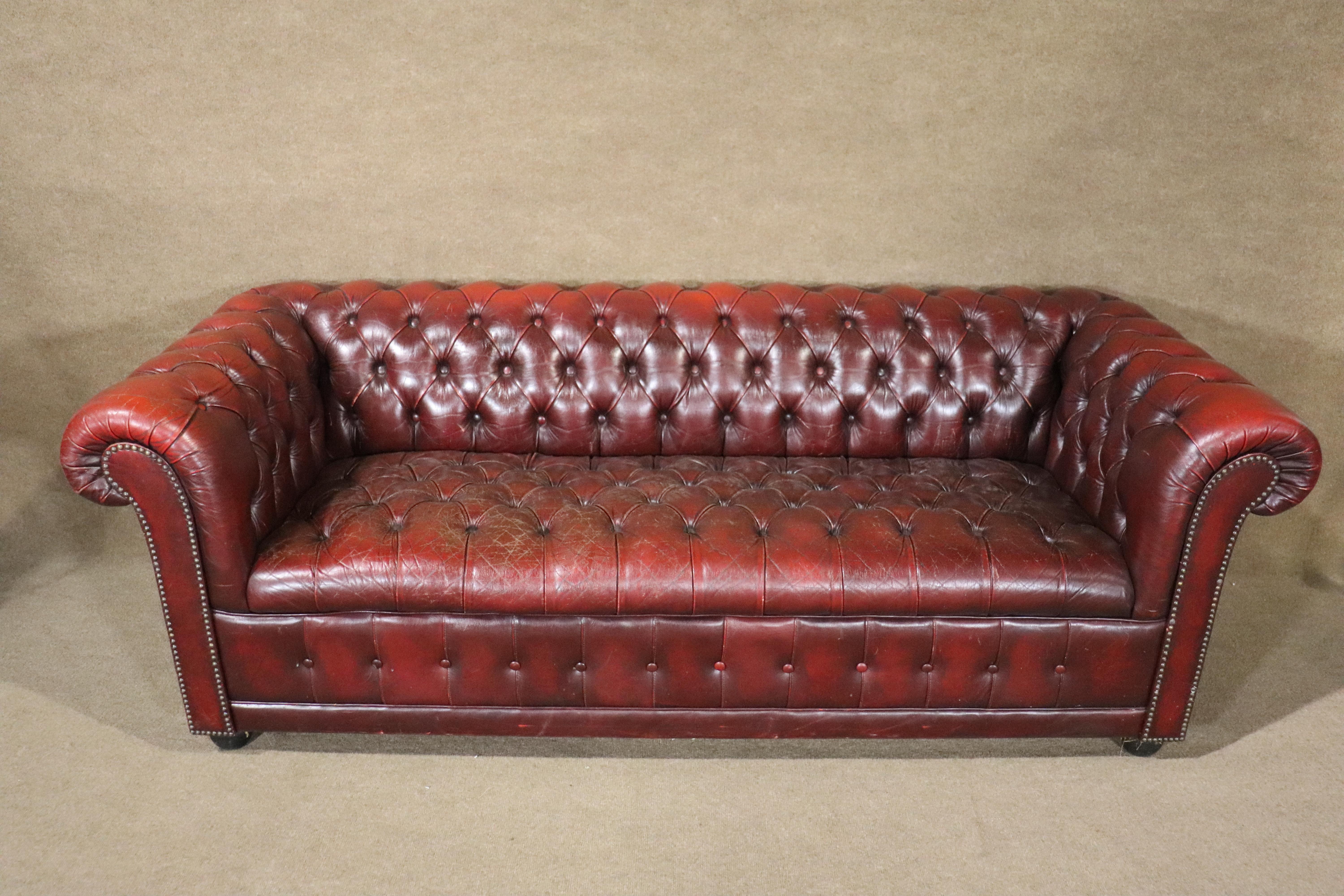 Long 6+ foot tufted sofa in deep burgundy leather. Great age and wear throughout.
Please confirm location NY or NJ