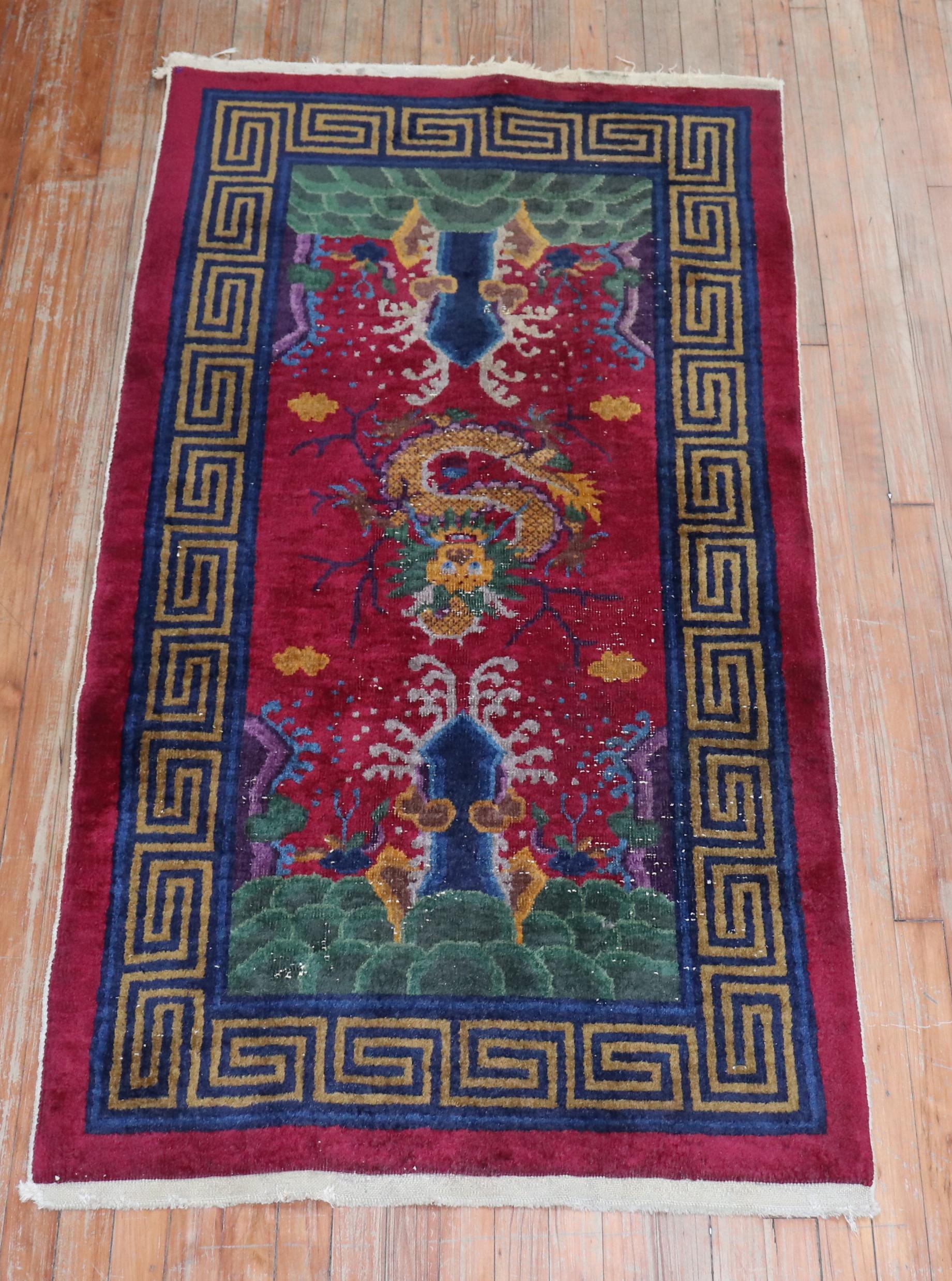A mid-20th century Chinese rug in burgundy and navy blue with a dragon motif medallion.

Size: 3' x 6'.

 