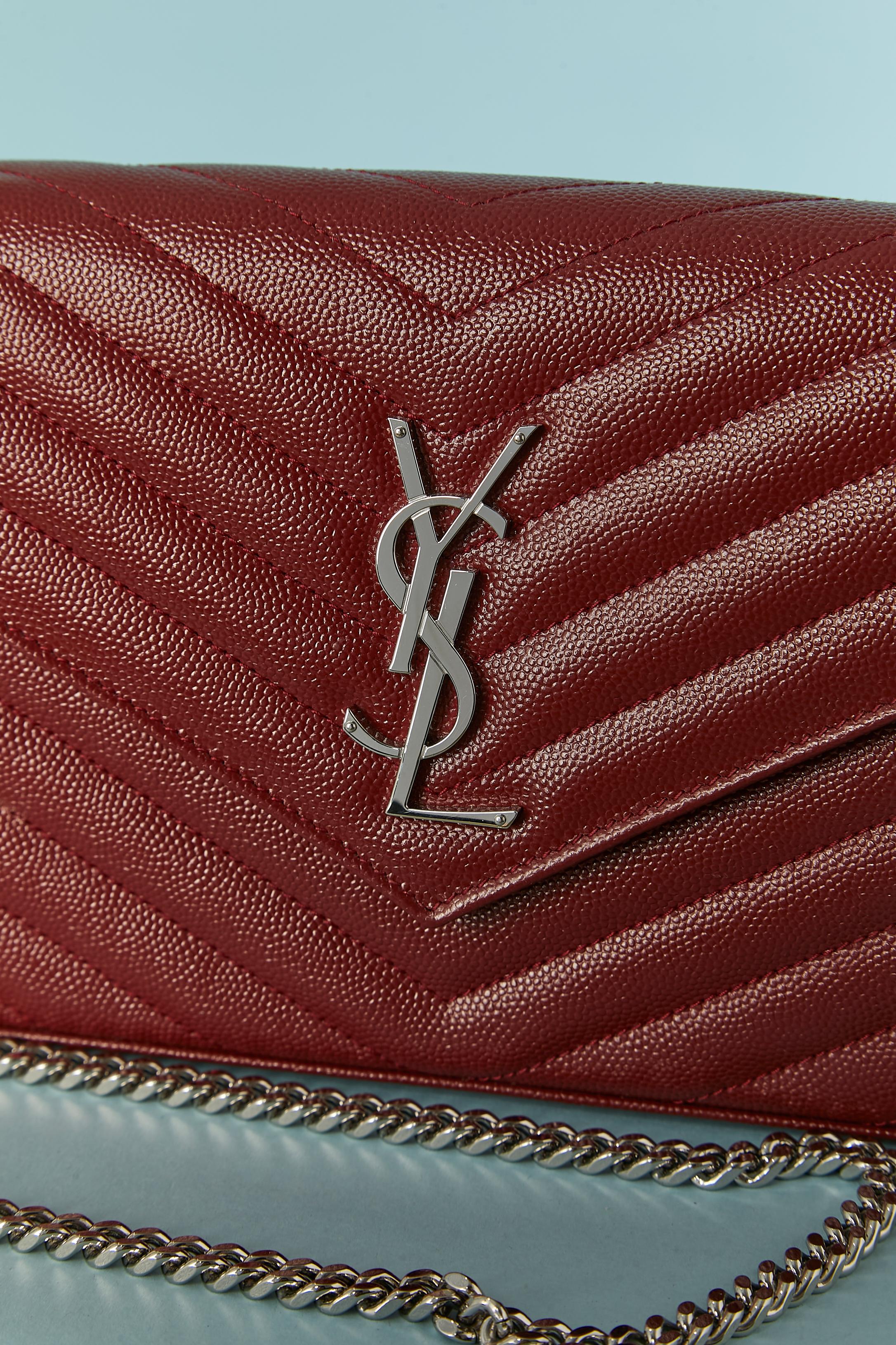 Burgundy grained leather bag with chain shoulder strap and top-stitching.
Detachable chain. 2 compartment + one pocket with zip and card holder. Snap closure under the flap. Black leather lining.
SIZE / 22cm X 14cm X 2cm 
Chain lenght : 105 cm 