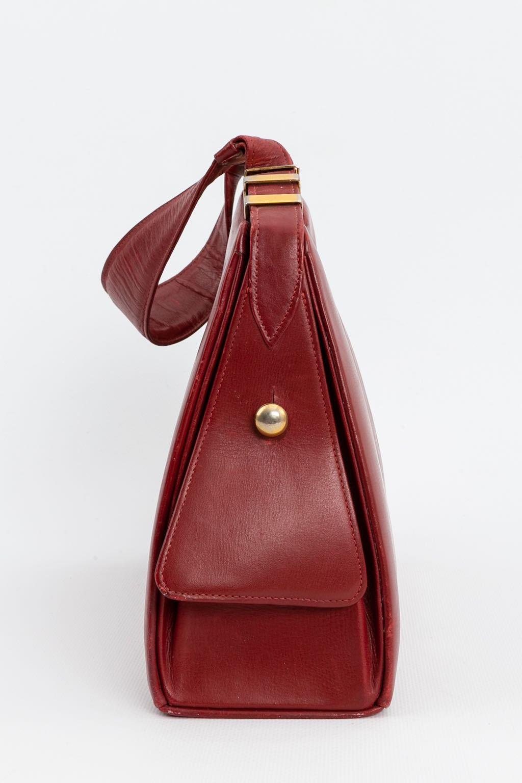 ANONYMOUS - Vintage bag composed of burgundy leather and gilded metal. It opens to three patch pockets. One small mirror.

Condition:
Very good condition, some wear on the handle leather

Measurements:
Height: 21 cm (8.26