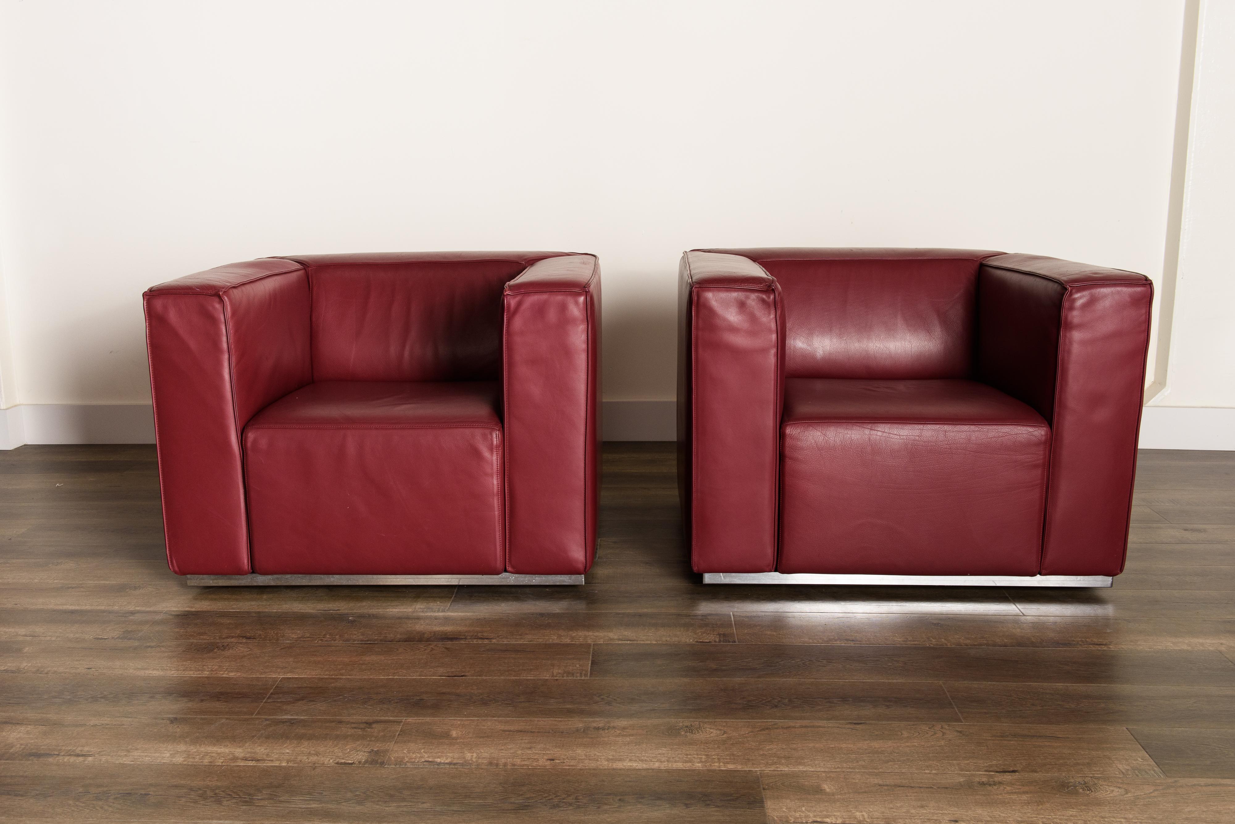 This incredible pair of 'Blox' club chairs by Jehs + Laub for Cassina are upholstered in high quality thick burgundy leather with a heavy steel frame and base wrapped in chrome. Highly comfortable, these leather club chairs can dress up any room