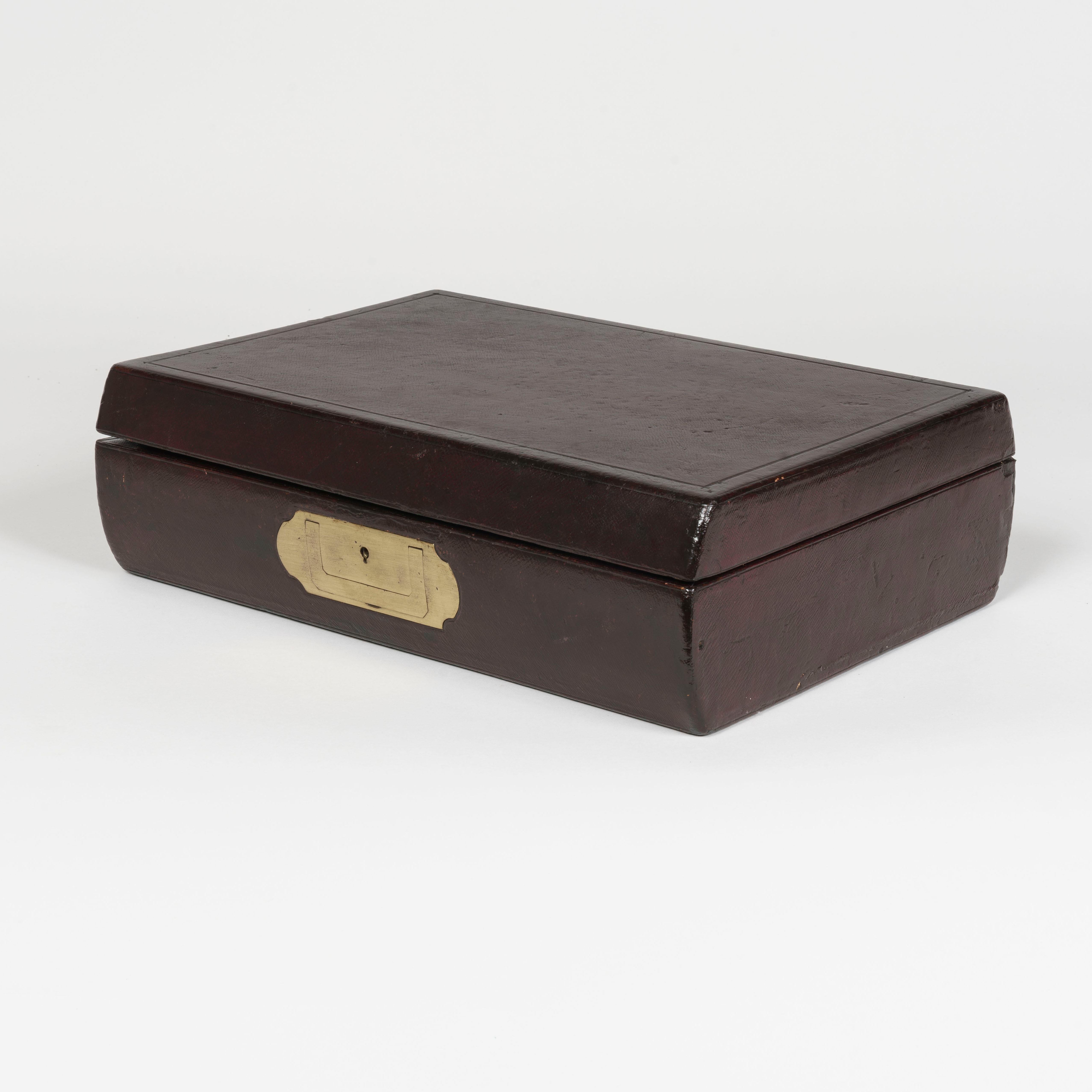 A burgundy leather bound writing and stationery box

Of the very highest quality, the carcass constructed from Cuban flame mahogany; the lockplate of shaped elliptical escutcheon form (and bearing stamps to the interior, 'London' & 'RS'), and