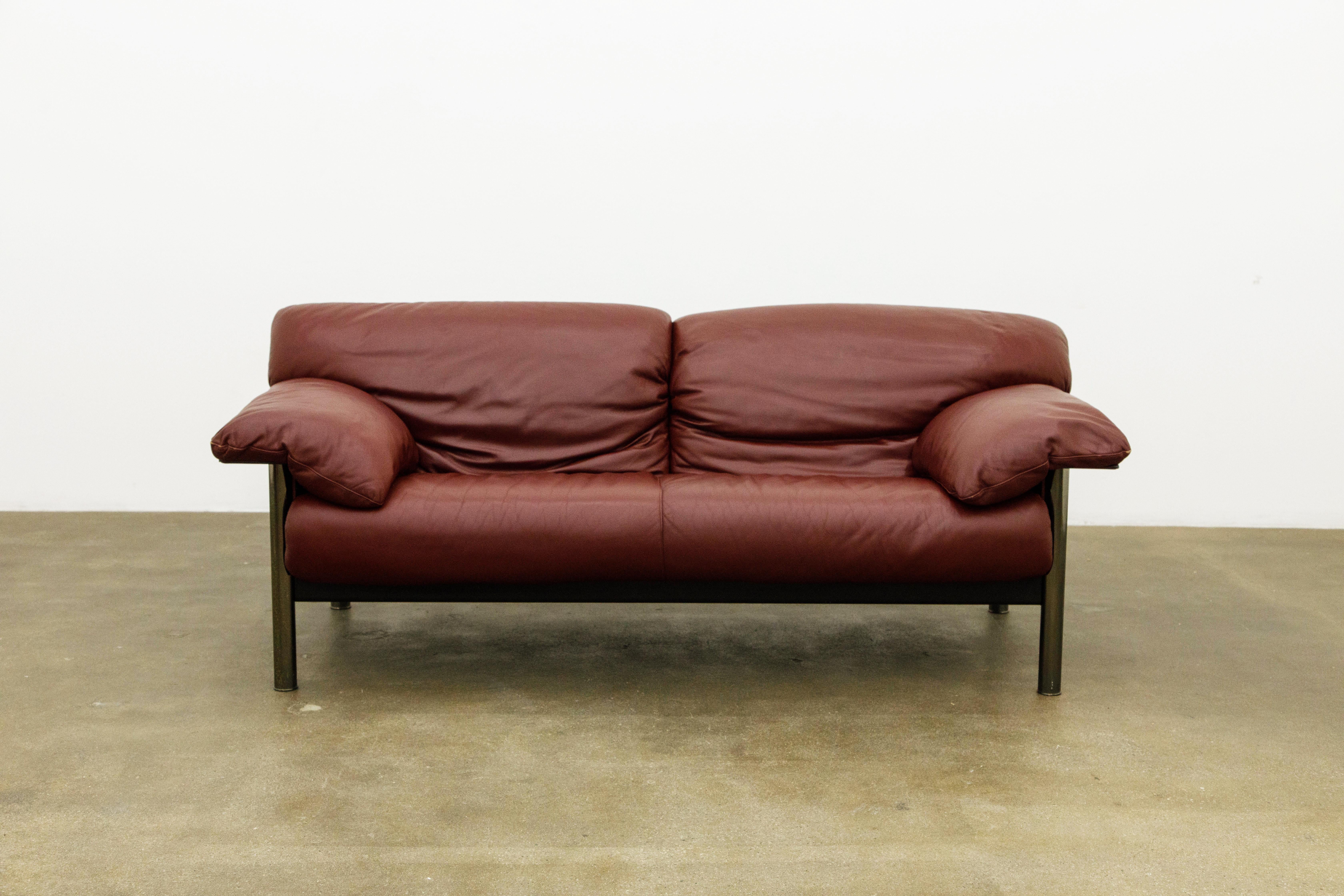 The burgundy leather is incredible on this Poltrona Frau circa 1990 Post-Modern sofa by Pierluigi Cerri. Featuring soft and supple Italian leather cushions over a ribbed leather wrapped (over steel) frame with smoked chrome legs, the rear has a