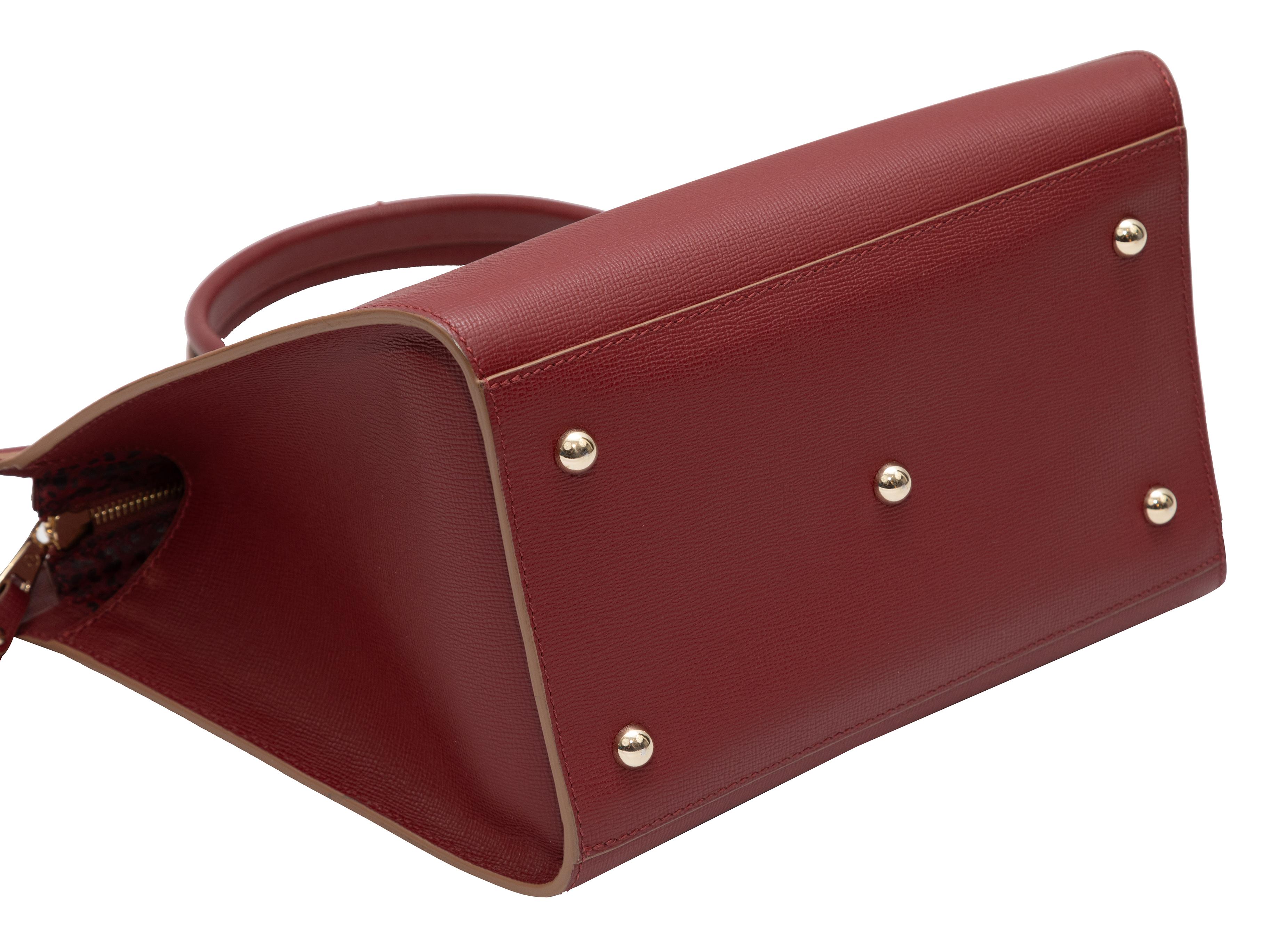 Burgundy Longchamp Le Pliage Leather Tote. The Le Pliage Tote features a leather body, gold-tone hardware, dual rolled top handles, an optional flat shoulder strap, and a top zip closure. 13