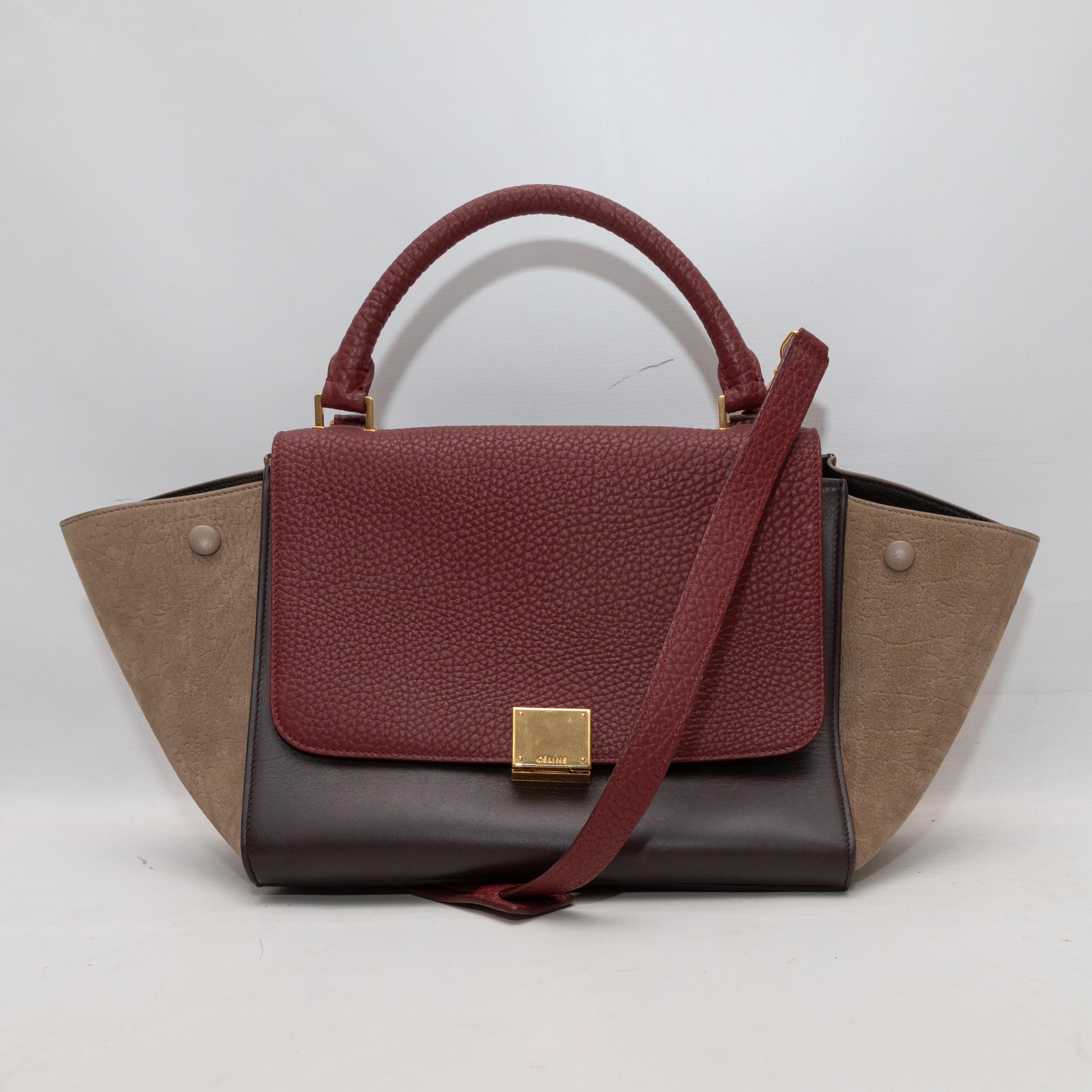  Burgundy & Multicolor Celine Small Tricolor Trapeze Bag. The Small Tricolor Trapeze Bag features a leather body, gold-tone hardware, a single rolled top handle, a back zip back, a single shoulder strap, and a front flap closure. 18.5