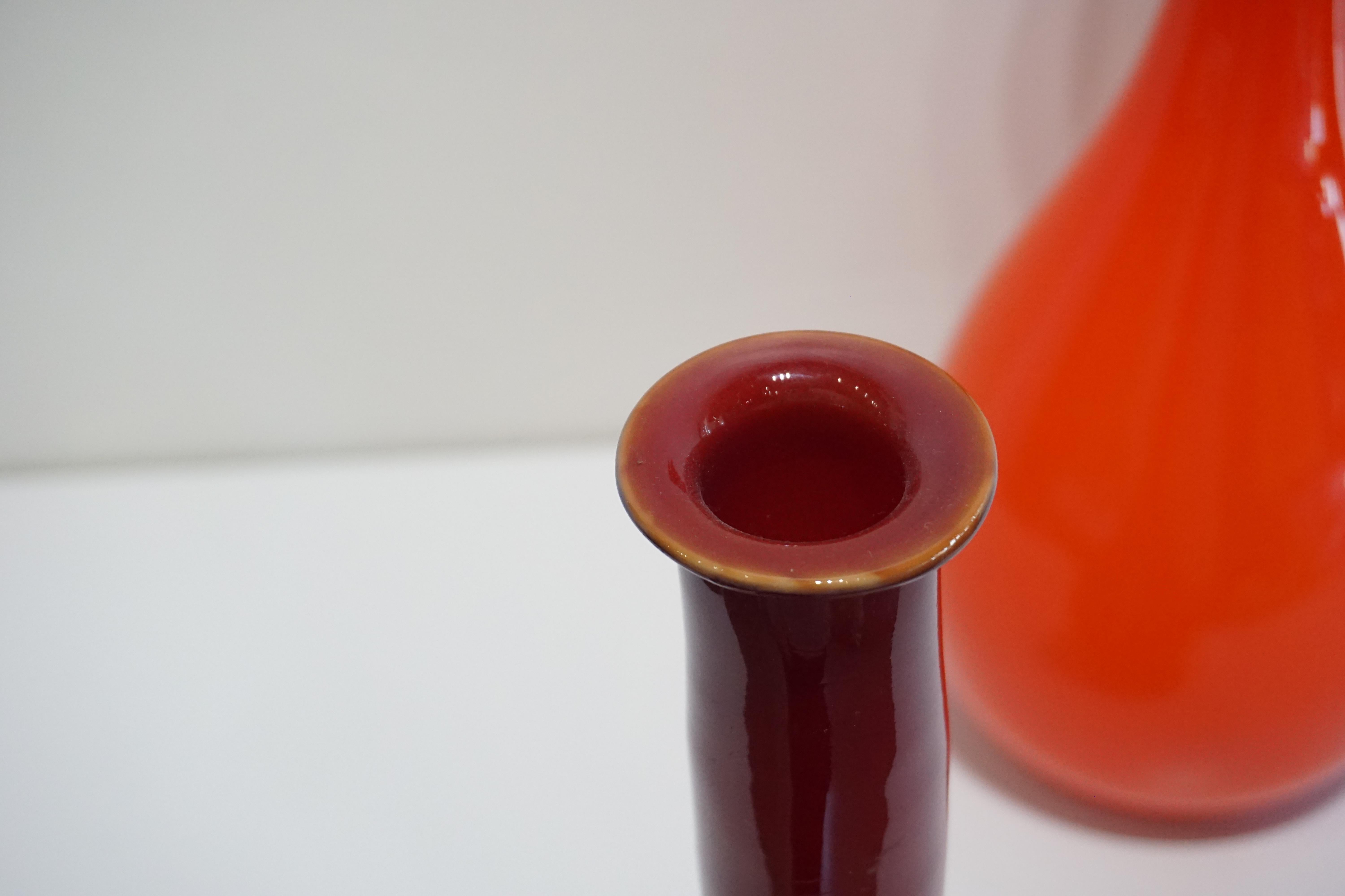 Vintage Burgundy Murano glass vase, in a genie bottle shape, featuring glass from the Venetian island of Murano, a place known for its production of vibrant and unique glass products. Unusual solid color, mouth blown, elegant in its simplicity.