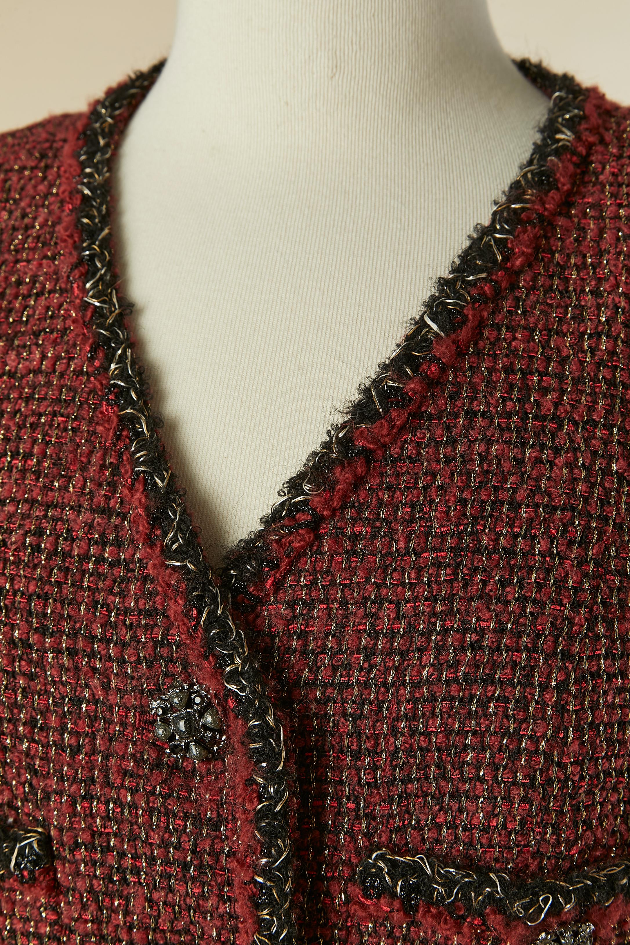 Veste en tweed bourgogne à simple boutonnage. Composition en tweed : 42% laine, 25% nylon, 21% rayonne, 9% mohair, 3% polyester. Doublure en soie. Bouton et boutonnière marqués sur le milieu du devant et sur les poignets. Mince pad d'épaule. Chaîne