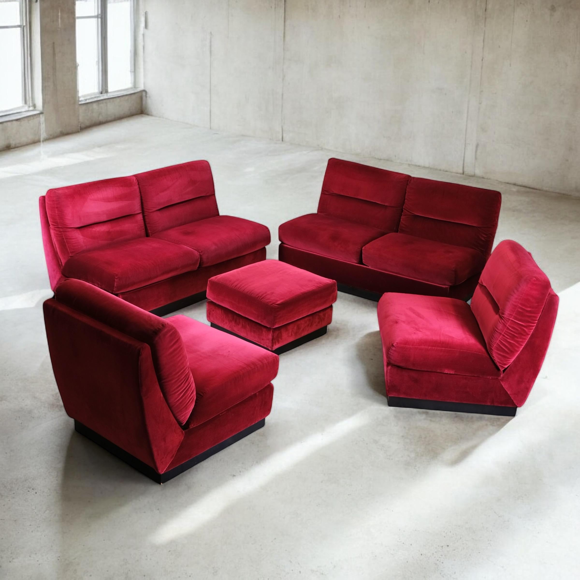 Nice burgundy velvet living room set, made in France in the 1980s, in the style of Michel Ducaroy's Albany or Jacques Charpentier.
Composed of two 2-seats sofas, 2 armchairs and one ottoman.
Black wood laminate on wooden base.
Overall good